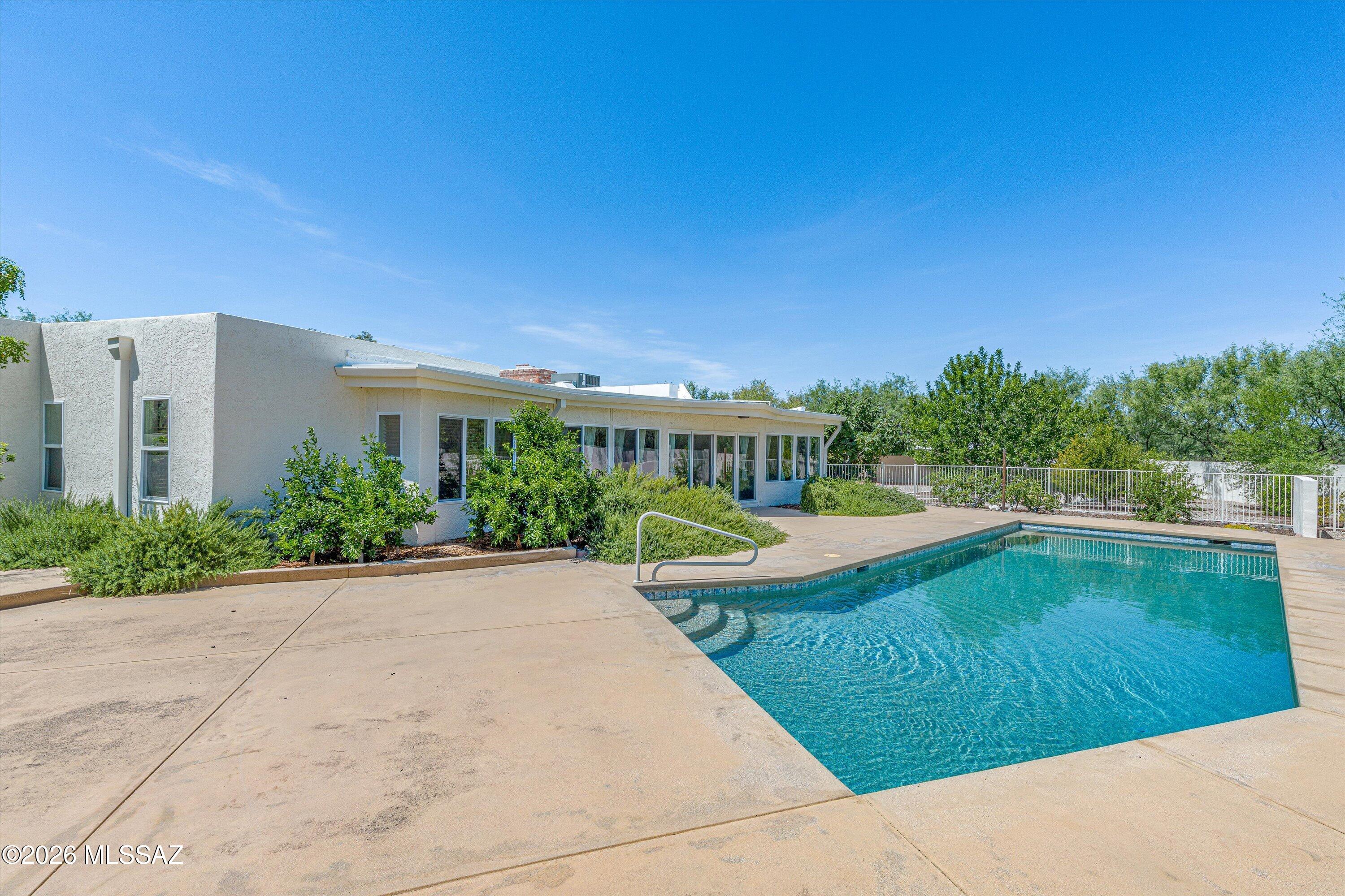 Spacious 5-bed, 4-bath ranch offering 3,888 sq ft of comfortable living space with Catalina Mountain views on 1 acre featuring pool, ramada, fruit trees, & dedicated garden space, seamlessly blending indoor comfort with outdoor enjoyment.

Fully renovated kitchen showcases granite countertops, stainless steel appliances, breakfast bar & cozy nook. Entertain with ease in formal living room, family room/dining area, enhanced by dual-sided fireplace. 

Expansive rec room complete with a wet bar, abundant storage, & walls of windows overlooking pool, creating the perfect space for gatherings. Comfortable primary suite has been fully renovated & features a soaking tub, walk-in shower, dual vanities with hands-free faucets. Additional highlights include all-new windows installed in 2025 for enhanced energy efficiency, detached 3-car garage with cabs for additional storage & workbench.

Offering privacy, tranquility, & convenience, this exceptional property is surrounded by the beauty of Tucson's desert landscape & mountain scenery. Neighborhood offers welcoming atmosphere & strong sense of community