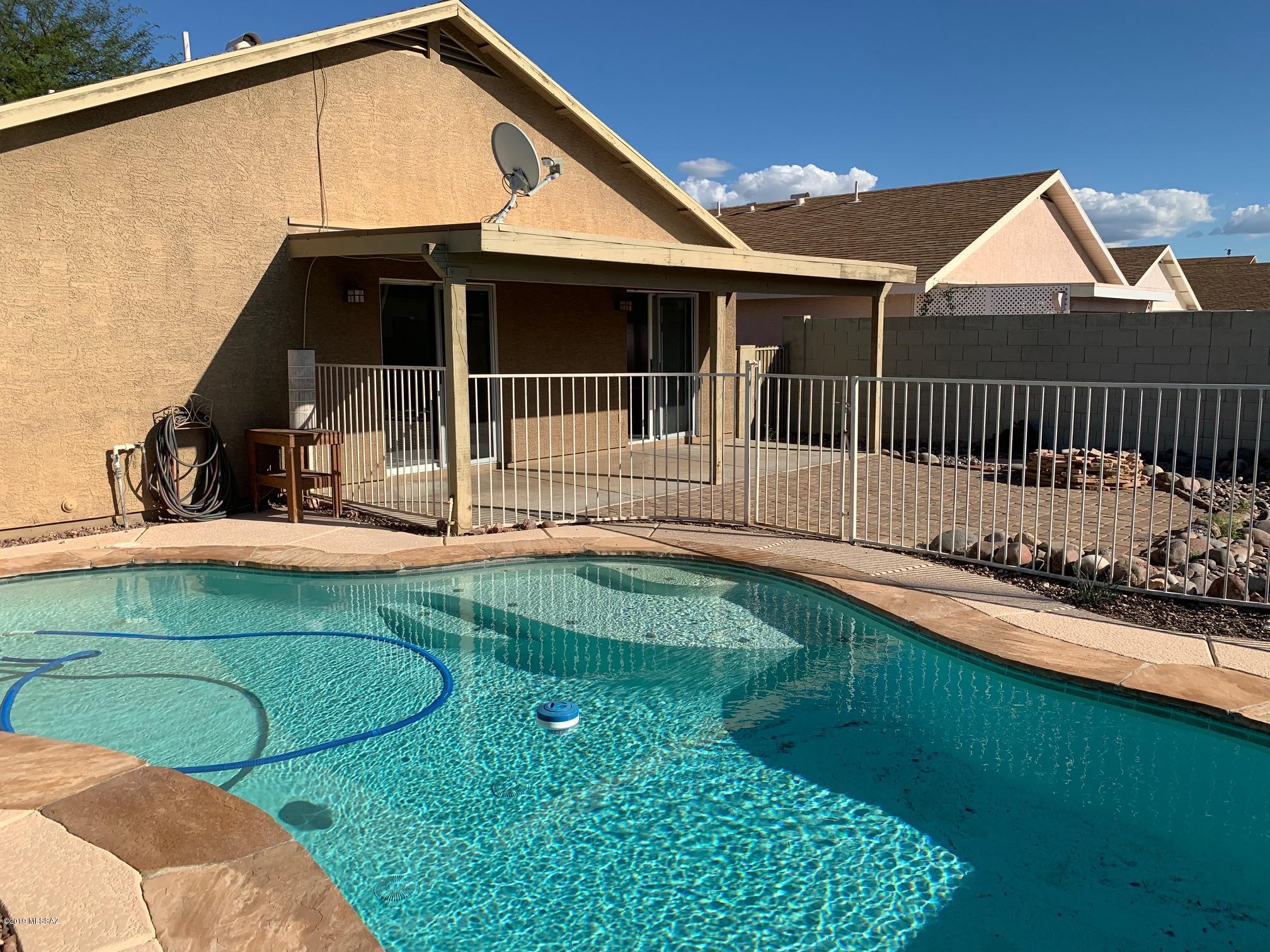 Adorable 3 bedroom, 2 bath with pool in Rita Ranch! Tile flooring throughout (no carpet!) Kitchen is open to both the living room and dining area and features dark brown cabinets and stainless-steel appliances.  Master bedroom has door to the backyard & pool area, walk-in closet and garden tub. Ceiling fans in all the bedrooms and living room. 2 car garage. Large covered patio leads to sparkling pool, extended brick patio with fire pit and artificial grass area - the perfect space for entertaining friends & family or just enjoying for yourself! Weekly pool service provided. Non-smoking home. One year minimum lease. Renters insurance required. $45 application fee per adult. Call listing agent for pet policy and additional costs for pets.