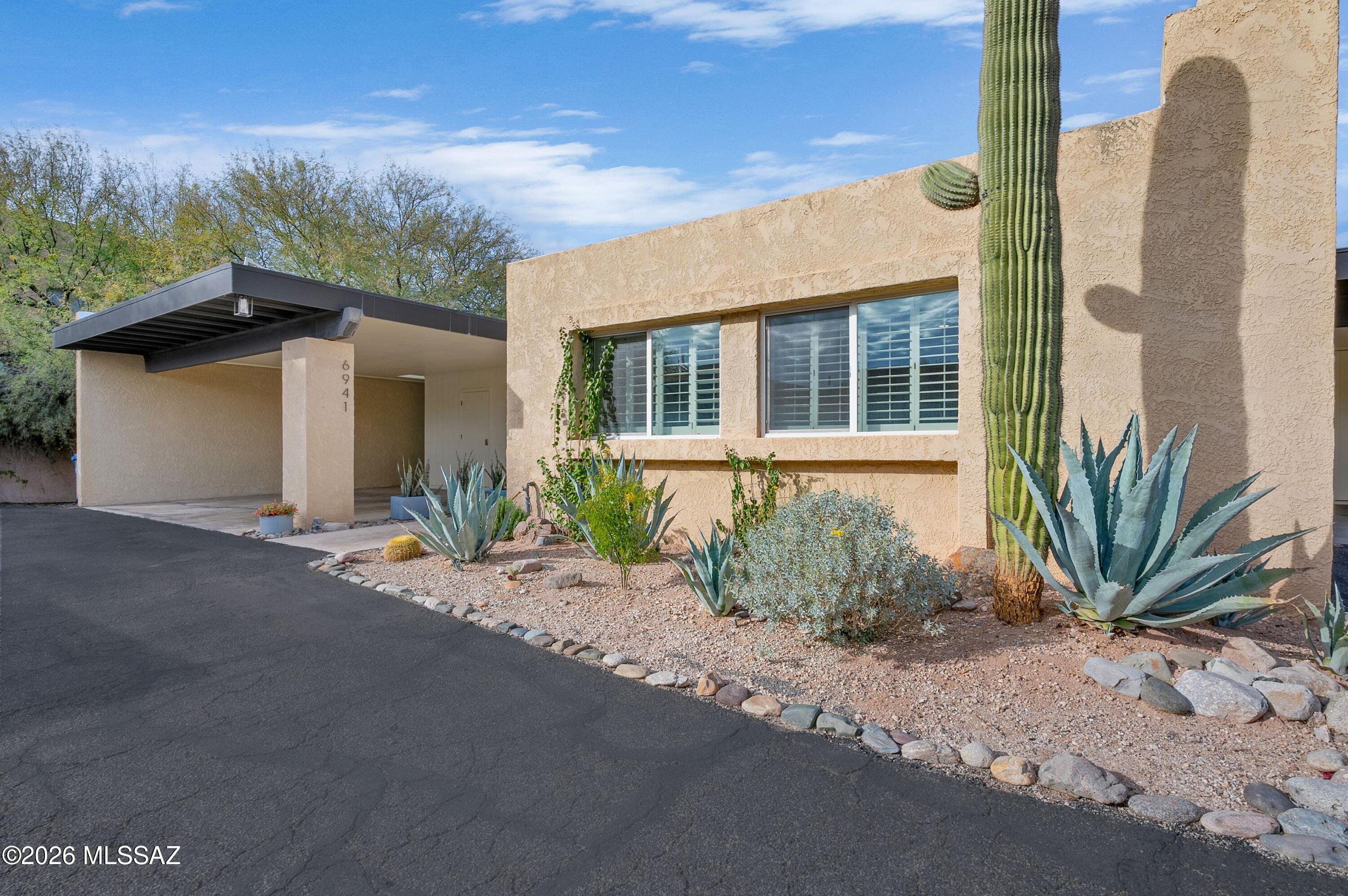 Beautifully remodeled corner-lot townhouse minutes from Sabino Canyon! This light-filled open-concept home blends modern luxury with authentic Southwest charm, featuring exposed wood beams and a cozy beehive fireplace. The premium European kitchen boasts quartz countertops, an oversized island, breakfast bar, induction cooktop, and convection rotisserie wall oven. Enjoy a low-maintenance, north-facing desert oasis out back--the private rear patio offers a peek of mountain views, serene landscaping, and wildlife watching. Nestled in a prime Northeast location near premier hiking/biking trails, dining, and shopping. Move-in ready desert living at its finest!