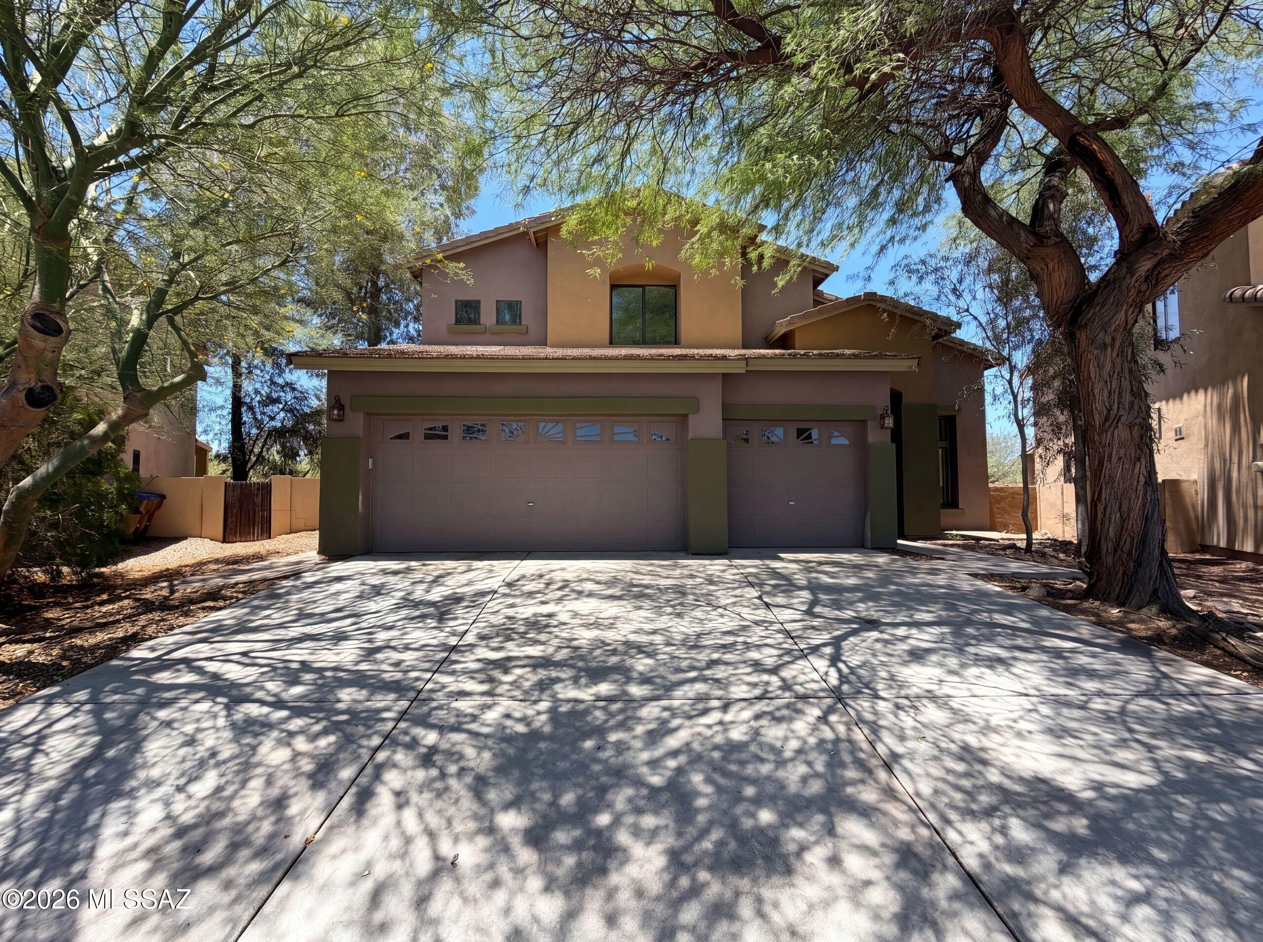 6 E Placita Vista Alegre, Sahuarita, AZ 85629 is a two-story Sahuarita single- home built in 2004 with generous square footage across both levels. The kitchen is laid out with wood cabinetry, granite countertops, a tile backsplash, a pantry, and a center island with a sink and breakfast bar seating that adds prep space and casual dining, along with stainless steel appliances for cooking and cleanup. Open living and dining areas with high ceilings and large windows define the main gathering spaces. Among the four bedrooms, one includes a walk-in closet for convenient storage and organization, and its bathroom has double sinks for shared morning use, a separate soaking tub, and a glass-enclosed shower. A second full bathroom double sinks and a tub-and-shower combination, and a half bathroom