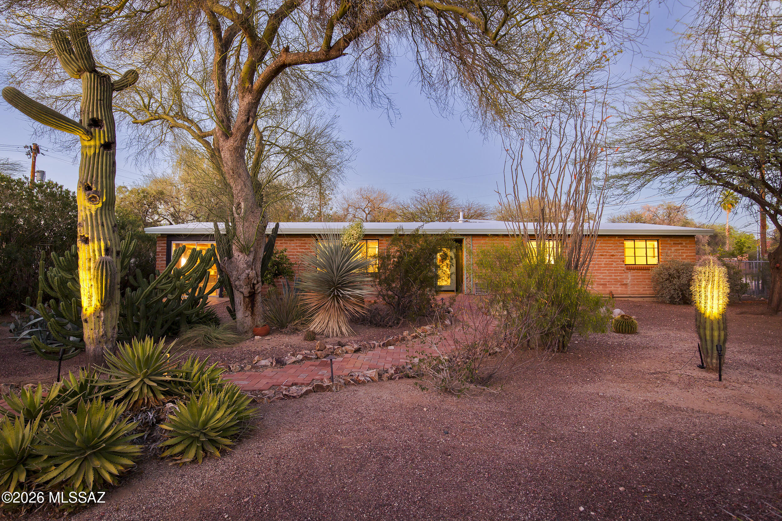 *** OPEN HOUSE CANCELLED***Historic Sam Hughes, c.1951. A burnt adobe ranch-style home, is an iconic mid century Tucson Architectural stlye,  rarely found outside the region. Polished concrete floors, exposed wood beam ceilings, and an open kitchen and living area create a warm, cohesive interior rooted in classic desert architecture.
Situated on a cul-de-sac and set back from the street, the home is quietly framed by lush desert landscape peppered with towering saguaros, offering both privacy and a connection to the Sonoran Desert. The floor plan includes 3 bedrooms, 2 bathrooms, and an additional family room providing flexibility for everyday living. A detached studio offers space for an office, workout room, or creative use. Two-car-carport access is provided by a rolling gate from the alley. Walkable to Himmel Park, Natural Grocers, Trader Joe's, the U of A bike path, and the cafés and offerings along the Sunshine Mile, the location balances neighborhood calm with easy access to some of Tucson's most loved amenities.
