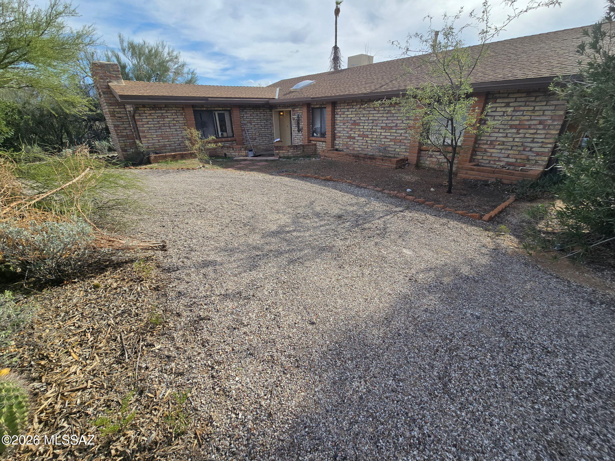 This is an estate sale and is being presented for sale AS-IS. Solid burnt adobe ranch home with wood beams and ceiling, with pitched shingled roof. Wood burning fireplaces in the family room and living room. 3 bedrooms with 2 bathrooms.  New heat exchange washer/dryer all in one unit. The HW heater was installed in 2020 and the HVAC in 2007. The pool was replastered in 2025.  Situated on just under 1.2 acres with views of the Catalina and Rincon mountains.  2-car garage with room to add more and separate storage building. Abundance of desert plants including a number of beautiful saguaros. This home needs new flooring. new appliances and updating (TLC).