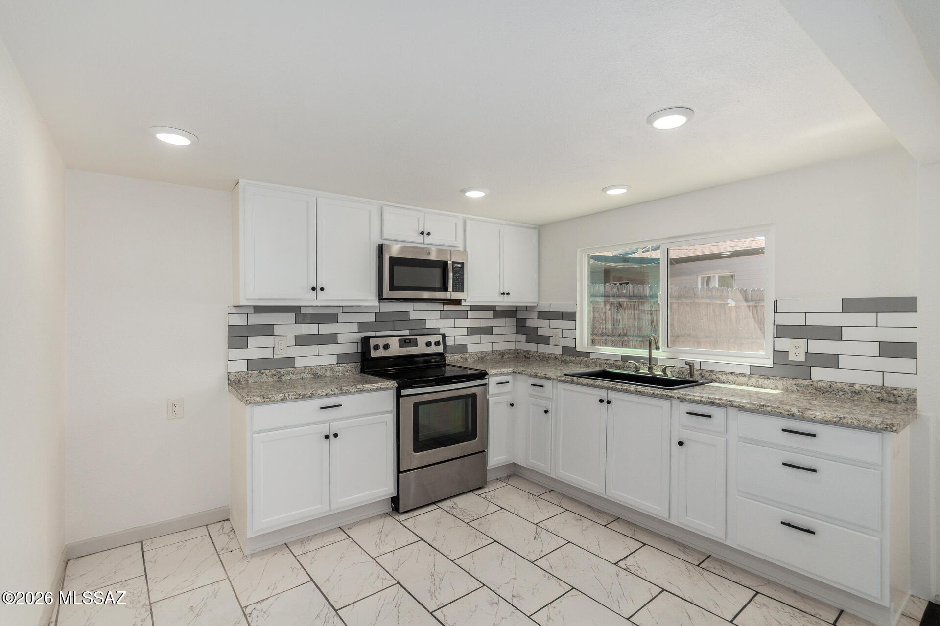 Looking for a place to call home? This recently renovated 2-bedroom gem is ready for you! Enjoy a cozy front porch ideal for quiet mornings or relaxing evenings. Inside, fresh paint, tile flooring, neutral tones, and dual-pane windows create a bright, inviting feel. The open floor plan maximizes space and natural light. The updated kitchen features recessed lighting, white cabinetry, subway tile backsplash, and stainless appliances, including an electric range and OTR microwave (existing - As Is). Both spacious bedrooms offer sliding-door closets and restful comfort. The large backyard is a blank canvas awaiting your creativity. This value won't disappoint! Agent/Owner.