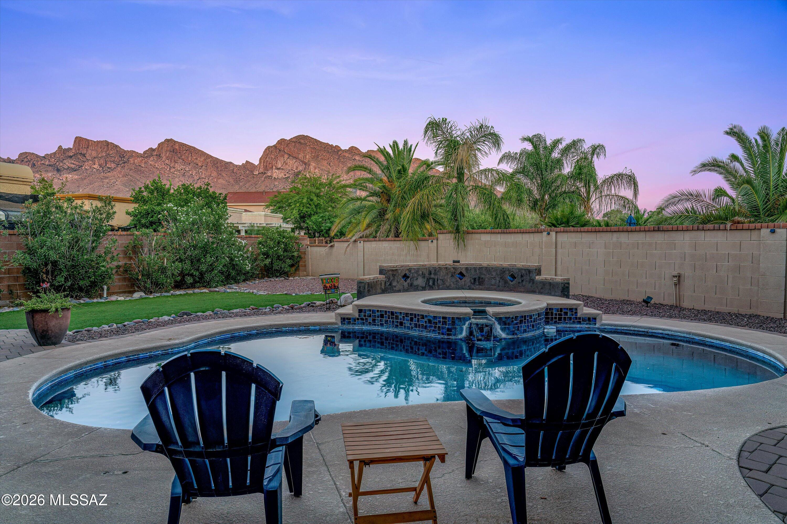 Unobstructed mountain views steal the show from this beautifully upgraded and meticulously maintained home in the gated Villages of La Canada. Featuring 3 bedrooms, 3 bathrooms, a spacious den/bonus room, and a 2-car garage, this Oro Valley retreat offers the perfect blend of comfort and elegance. Enjoy breathtaking sunsets from the private balcony off the primary suite, or relax in your resort-style backyard oasis complete with a sparkling pool, spa, and lush custom landscaping. The family room with fireplace opens to the kitchen, creating the perfect space to take in some of the most spectacular views Oro Valley has to offer.
