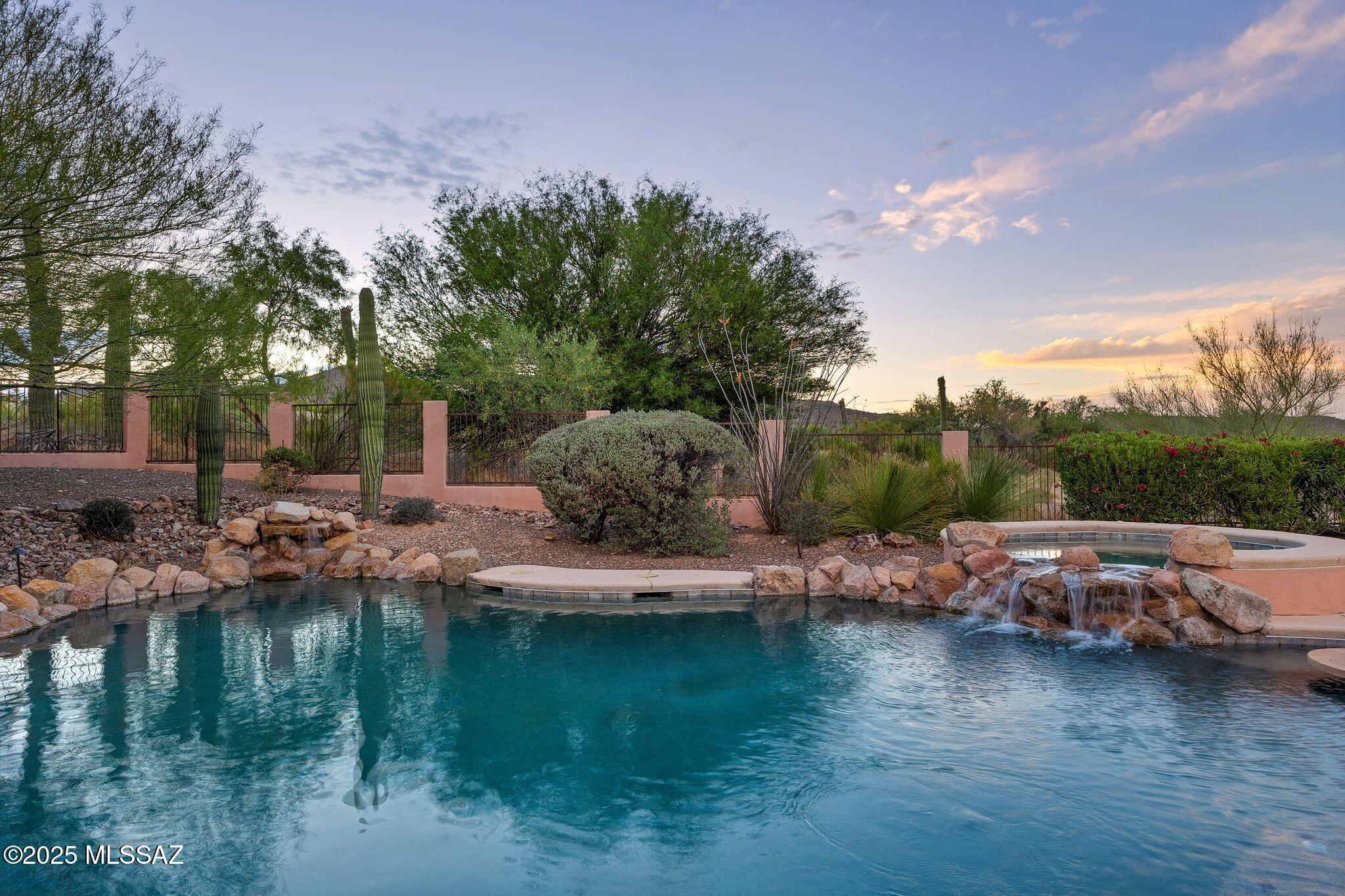 Starr Pass stunner!! Gaze over a lush back yard & pristine pebble tec swimming pool with heated spa onto natural desert & mountain views. Mature landscaping includes real grass, blooming shrubs & mature shade trees. Private length back patio allows for multiple conversation areas & entertaining space or quiet coffee sunrises & wine sunsets. Well appointed kitchen has hickory cabinets, island w prep sink, multiple pantries & stainless steel appliances! Kitchen opens to a breakfast area & great room w cozy gas fireplace. High ceilings allow for full view windows! Formal living & dining rooms, 326 sq ft detached casita w full bath. Woodburning kiva fireplace. Metal clad garage doors & space for 3 cars, storage & workshop. Minutes to JW Marriott Resort & Spa. Tucson resort living at it's fine