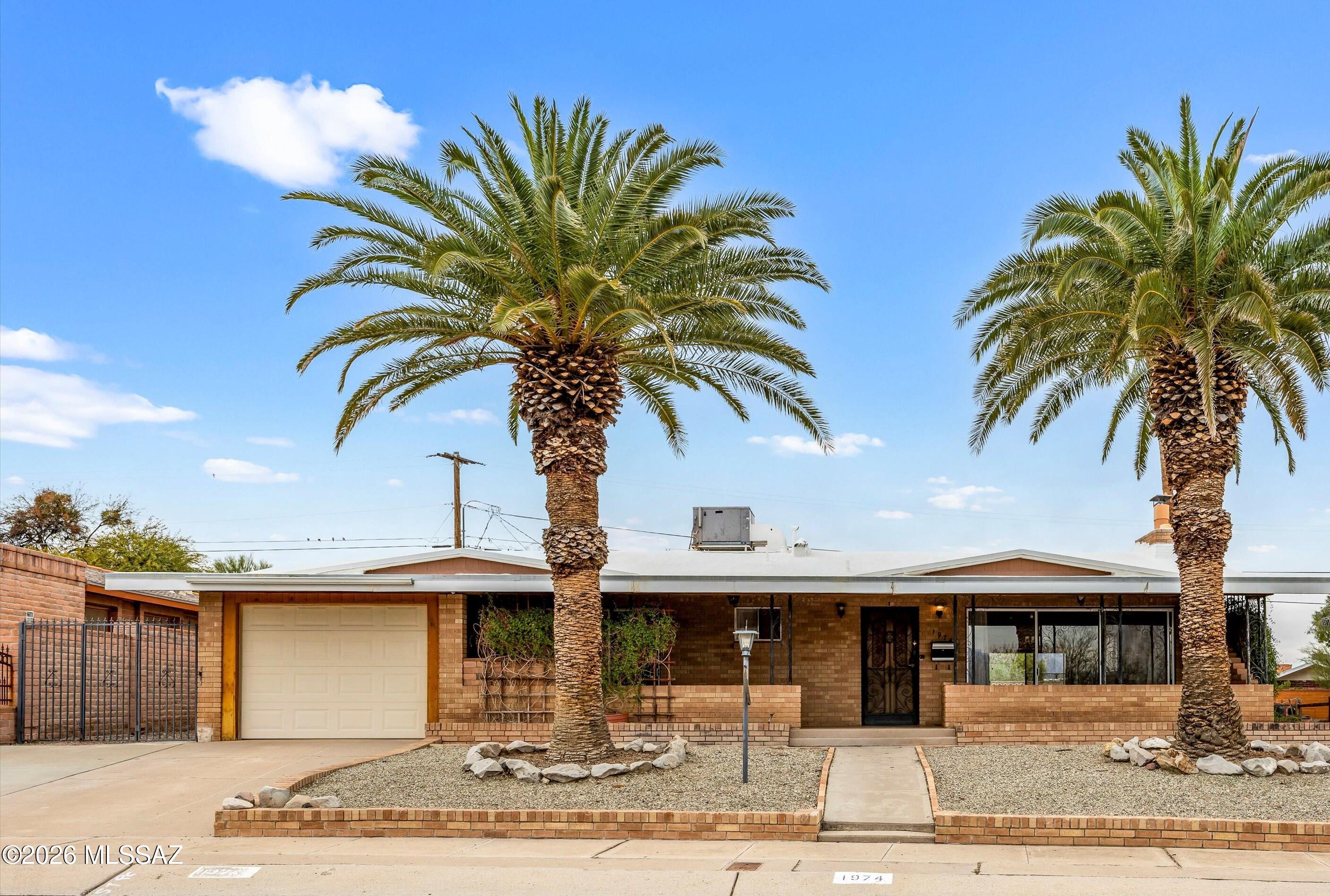 Fantastic & affordable opportunity to live in Santiago Hills near the base of Tumamoc Hill.  The prominent 9 X 39 front porch with Catalina Mtn views thru the majestic palms defines this 1960's rancher combined with other architectural features such as stacked stone accent walls concealing cabinetry and shelving, stacked stone fireplace with raised hearth, and unique cove molding throughout with fan-comb textured ceilings.  Other features inc. an open floorplan with oversize sliding doors, a surprisingly large kitchen, built-in hallway desk, and a ''bonus'' room off the garage with heating/air (perfect for a home office, workshop or hobby room).  AHS Home Warranty included.  Estate sale ''as is''.