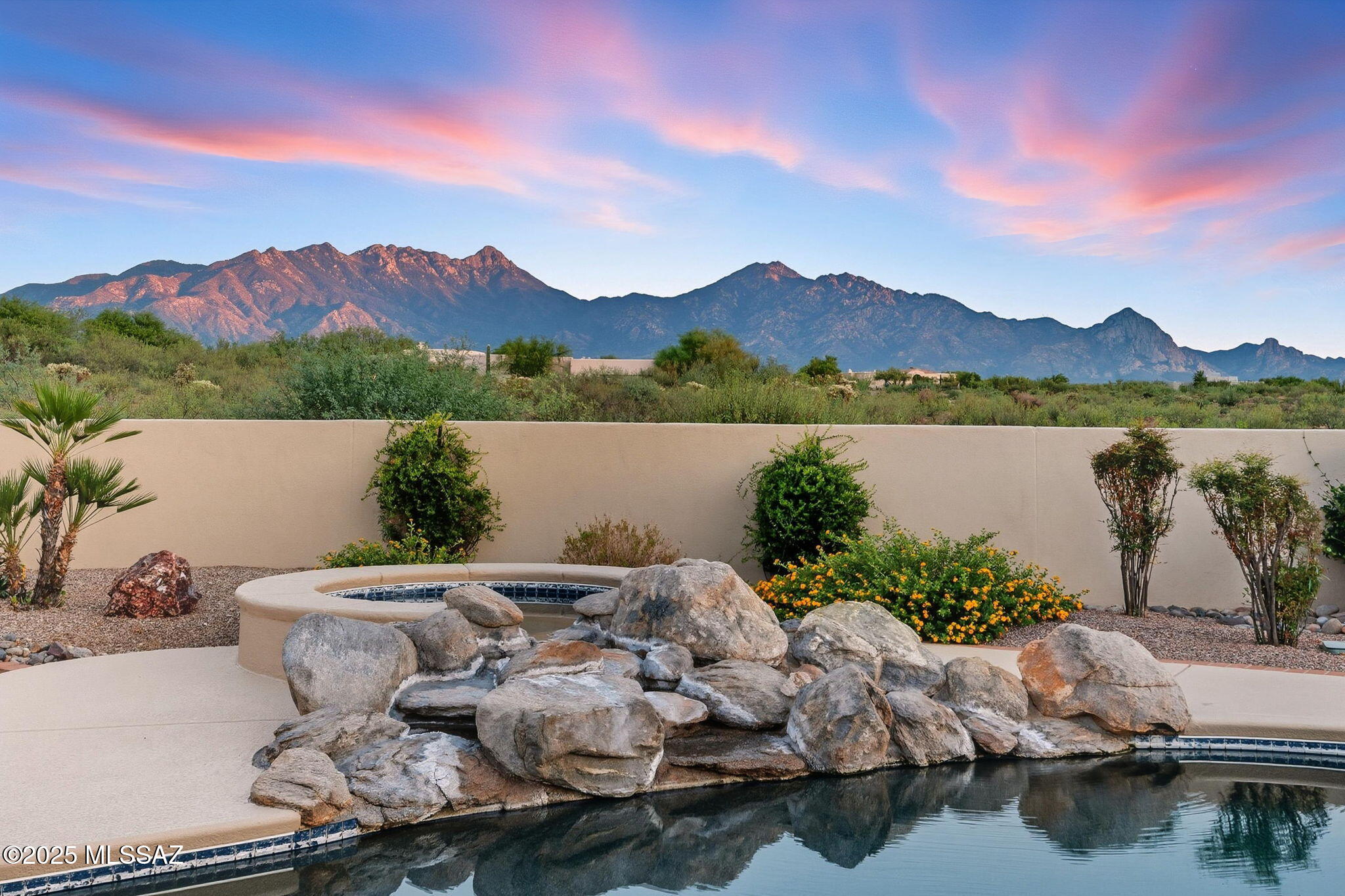 ONE-OF-A-KIND DESERT OASIS WITH  A MAJESTIC MOUNTAIN BACKDROP! Framed by the dramatic beauty of the Santa Rita Mountains, this extraordinary property offers a rare combination of privacy, luxury, and lifestyle amenities. A newly completed $42,000 circular concrete driveway provides an impressive approach to the home and its attached 4-car garage, fully outfitted with built-in storage cabinets, a utility sink, central vacuum, and water softener. Beyond the home itself, the property is enhanced by a brand-new 2,000 sq. ft., 5-car detached garage and shop—valued at over $250,000—offering exceptional quality and versatility. It's fully equipped with a new HVAC, a private office & bathroom, it's a dream space for hobbyists or collectors. Car enthusiasts will also appreciate the negotiable a lift, while a 2018 Yamaha fuel-injected golf car is available under a separate bill of sale. To ensure lasting privacy and preserve the panoramic mountain setting, surrounding lots are also available for purchase. Inside, thoughtful design meets everyday comfort with two Jack-and-Jill bedroom suites, each connected by a private studyideal for homework, reading, or quiet retreats. The primary suite exudes elegance and warmth with its own fireplace, while a second fireplace enhances the inviting family room. A dedicated home gym with private shower adds flexibility, and entertainment shines in the custom theater room, outfitted with all-new electronic equipment for the high-end movie system. A new whole-house intercom system provides seamless communication throughout, complementing the home's modern upgrades. Music flows room-to-room with ceiling speakers throughout the homeand out onto both  patios. Step outside to enjoy a true resort setting: a sparkling pool with spa and waterfall, framed by new cool decking, freshly grouted water features, and brand-new equipment including a 3 HP pump, motor, cartridge filter, salt chlorine cell, and Atlas suction cleaner. Lush new landscaping blends with mature trees, while a private putting green and observation deck create endless opportunities for fun, leisure, and star-gazing under Arizona skies. Expansive covered patios are ideal for entertaining family and friends.

Every detail of this home has been carefully updated to ensure comfort and confidence for years to come. Three new Rheem HVAC systems with smart thermostats keep the home perfectly climate-controlled, while high-end KitchenAid appliances, including a $13,000 refrigerator, elevate the kitchen experience. A Kinetico water system with reverse osmosis provides pure convenience, complemented by refreshed LED lighting, ceiling fans, exterior paint, and roof updates.

This property isn't just a homeit's a private desert retreat designed for living, entertaining, and creating memories. With breathtaking mountain views, top-tier upgrades, and unparalleled privacy, it's a one-of-a-kind offering in Southern Arizona.
