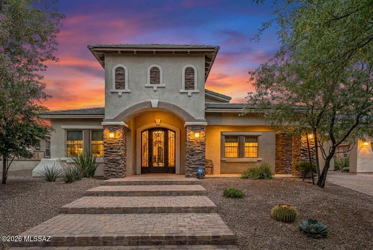 Located within the exclusive gated enclave of Hacienda Del Lago in Rancho Sahuarita, this remarkable semi-custom home offers a rare opportunity to own in one of the community's most private and sought-after neighborhoods, where homes seldom become available. Just steps from the lake, fitness center, tennis courts, water park, and premier amenities, the lifestyle here is as exceptional as the home itself.
Set among only 18 distinctive residences, this one-of-a-kind property is a true standout gem, blending elegance, thoughtful upgrades, and refined comfort throughout. A stunning iron entry door welcomes you in, complemented by brick-accented stairs, soaring ceilings, and a light, bright, and airy ambiance that flows seamlessly from room to room. The grand entrance is enhanced by a partially covered brick driveway, offering both architectural charm and additional parking. Inside, the home features a highly desirable layout, including a private en suite bedroom in addition to the luxurious primary suite. The primary retreat showcases an updated soaking tub, a beautifully tiled glass walk-in shower, and spa-inspired finishes. Every bathroom throughout the home has been upgraded with custom tile work, adding a cohesive and elevated design.
At the heart of the home, the kitchen is a true showstopper, an outstanding centerpiece designed to impress. Crisp white cabinetry, upgraded granite countertops, and premium stainless steel KitchenAid appliances create a space that is both functional and visually stunning, with abundant storage and thoughtful design at every turn. Upgraded lighting throughout the home further enhances its modern, polished feel.
The spacious laundry room mirrors the kitchen's design with matching cabinetry, a utility sink, generous folding space, and a window overlooking the backyard, bringing both beauty and practicality together.
The garage offers a 4-foot extension, ideal for additional storage, hobbies, or accommodating larger vehicles. Outdoors, the backyard is designed for both relaxation and play, featuring low-maintenance artificial turf and an in-ground trampoline, creating the perfect environment for entertaining or everyday enjoyment.
This exceptional property delivers a rare combination of luxury, location, and uniqueness. Welcome home