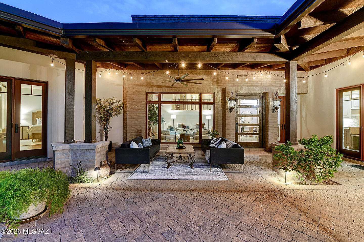 Stunning Territorial estate in the Gated Ventana Entrada enclave of Ventana Canyon CC. Rich character & craftsmanship, w/ a privately gated courtyard entry, soaring ceilings, exposed beams, brick accents, clerestory windows, MOUNTAIN VIEWS & a striking mix of concrete, marble & wood floors. Custom wrought iron chandeliers, fixtures & hardware elevate the timeless design. Open Great Room plan is ideal for entertaining, anchored by a dramatic 2-sided FP shared w/ the formal Dining Rm. Impressive chef's kitchen w/large marble island, 6-burner gas range, farm sink & Butler's Pantry. Main-level Primary Suite offers a spa-inspired bath w/ soaking tub, separate shower & dual walk-in closets;Kids/guest wing boast 2 bds w/ensuite baths & den. Executive home office &  separate guest house -*SEE MORE Guests will never want to leave the attached delightful casita with it's living room, generous bedroom (5th bd) featuring a wall of windows framing remarkable mountain views and terrific privacy.  A bonus room has served as a home gym but would also be a terrific game room or studio. Absolutely marvelous!