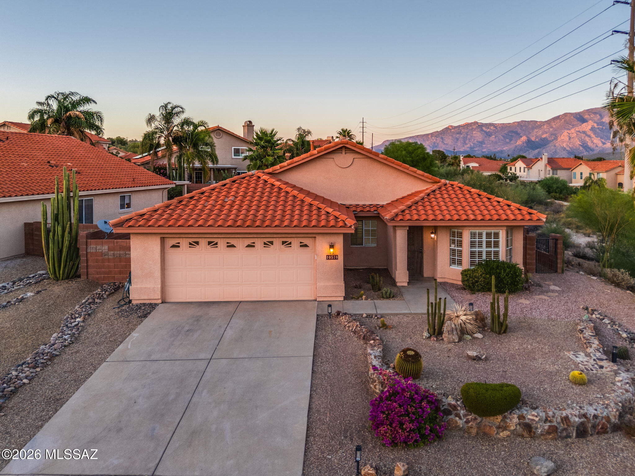 Seller shall accept or counter offers ranging between $425,000-445,000. STUNNING PUSCH RIDGE VIEWS FROM THIS ELEVATED ORO VALLEY HOME! Perfectly positioned on a premium lot adjacent to open space, this single-story 3-bedroom plus den residence offers privacy and a peaceful desert setting. Inside, the thoughtfully designed floor plan presents flexibility with both living and family rooms, plus a versatile den ideal for a home office, fitness space, media room, or potential fourth bedroom. Vaulted ceilings and abundant natural light from large windows create an open, airy feel throughout. Recent updates, including new flooring, kitchen countertops, and appliances, make the home move-in ready. The kitchen serves as the centerpiece of the home, anchored by a large island and framed by unobstructed mountain views. The spacious primary suite is complete with double French doors, an oversized walk-in closet, soaking tub, separate shower, and dual vanities.
Enjoy year-round outdoor living with a screened-in Arizona room and Northeast-facing low-maintenance backyard. Located in sought-after Oro Valley, enjoy access to hiking and biking trails, golf courses, parks, and everyday conveniences, all set against a striking desert backdrop.