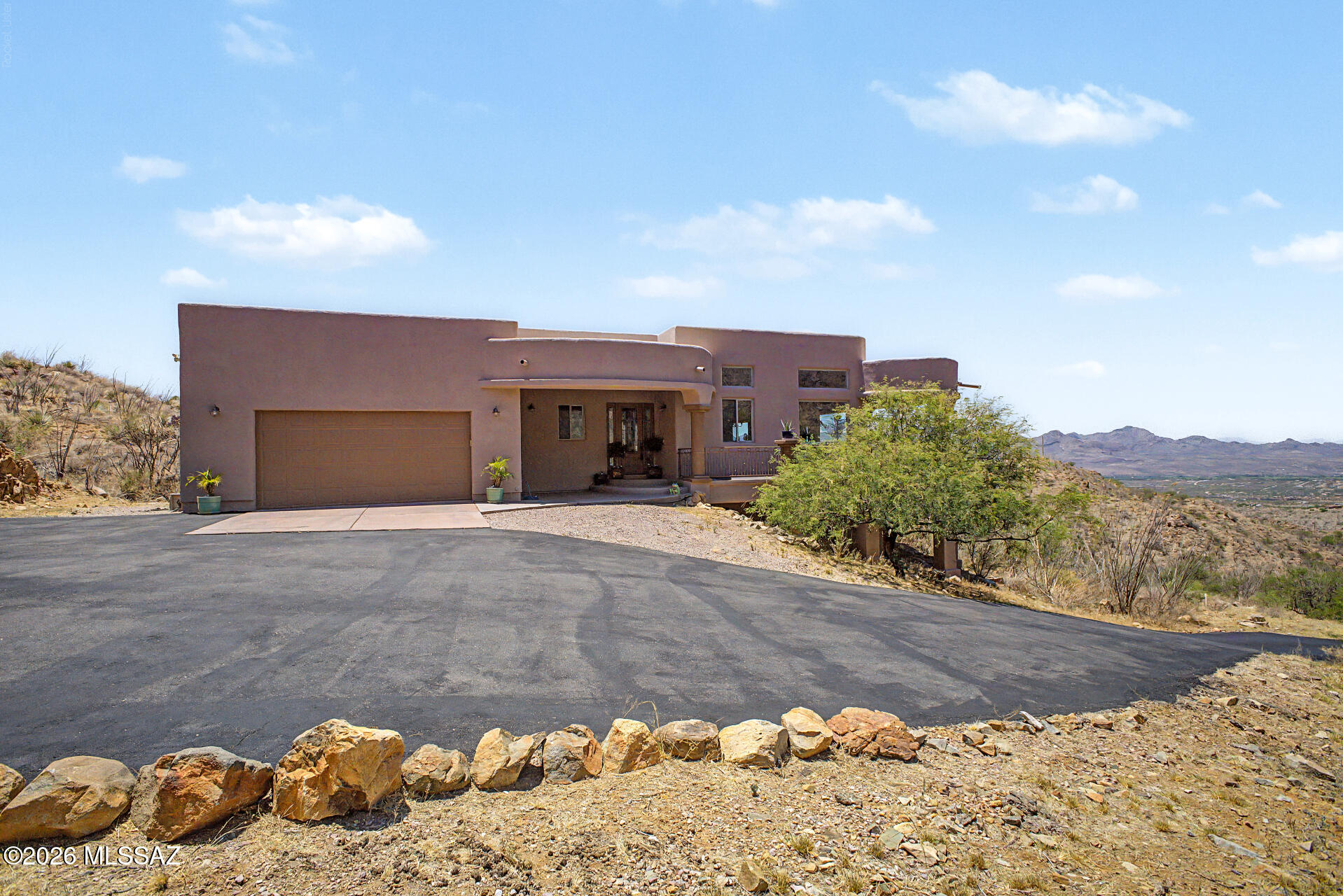 Perched high above the valley, this exceptional 3,456 sq. ft. custom home offers breathtaking panoramic views stretching across Rio Rico, Sahuarita, and the surrounding mountain ranges. Meticulously maintained and being sold fully furnished, this one-of-a-kind property combines luxury, comfort, and timeless design in an unforgettable setting.

The heart of the home is an expansive great room designed for both relaxation and entertaining, featuring a gas fireplace, elegant finishes, and walls of windows that frame the stunning desert landscape. The spacious kitchen is equipped with GE Profile black stainless appliances, beautiful hickory cabinetry, and a generous walk-in pantry.


Home is being sold fully furnished. See more section & attached documents for details Step outside onto the impressive 1,200 sq. ft. wraparound deck, where you'll enjoy unforgettable sunsets, sparkling city lights, and endless mountain vistas. Whether hosting guests or savoring a quiet morning coffee, the outdoor living spaces offer a true Arizona lifestyle experience.

The main-level primary suite serves as a private retreat with direct deck access and a spa-inspired bath featuring a soaking tub, dual-head walk-in shower, copper sinks, and dedicated makeup vanity. The lower-level guest quarters provide exceptional flexibility with a private bedroom, living area, bath, and patio access ideal for visitors, multigenerational living, or extended stays.

Adding extraordinary value, the home conveys with a curated collection of designer furnishings and artisan-crafted pieces. Highlights include a stunning Century Furniture dining table, Baker Furniture leather club chairs, a custom 98-inch designer sofa, imported furnishings, handcrafted mesquite accents with turquoise inlay, and an impressive primary bedroom suite. Every piece has been thoughtfully selected to complement the home's character, craftsmanship, and refined elegance.

This is more than a home it's a fully furnished luxury retreat where unmatched views, exceptional quality, and timeless design come together in one remarkable property. Schedule your private showing today and experience the beauty of Rio Rico living at its finest.