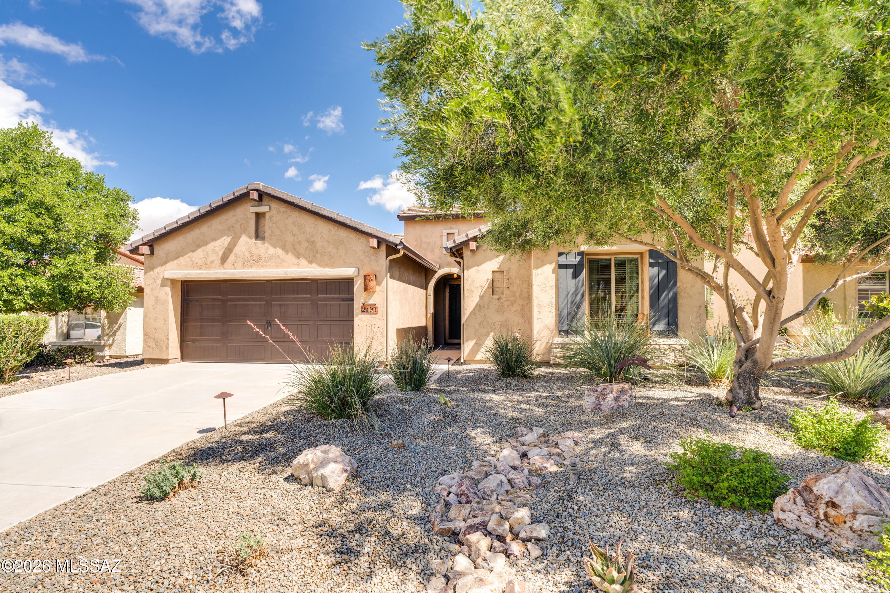 This attractive Southwest-style 1,589 sq. ft. Baja model in Quail Creek offers 2 BR, 2 BA + Den and showcases a warm stucco exterior and inviting curb appeal. Enter through the front wrought iron security door into a welcoming foyer that sets the tone for a bright, eclectic interior filled with color and personality. The entry features vibrant, nature-inspired wallpaper, creating a striking first impression. Beyond, the home opens to a modern great room highlighted by bold design elements, including rich blue and warm coral accent walls, a contemporary ceiling fan, and large windows that flood the space with natural light. The eye-catching kitchen is designed for both function and style, featuring warm coral-red walls, dark wood cabinetry, stainless appliances, granite counters, and is complemented by a pantry closet, single-bowl stainless sink, and gas range. A large island with warm pendant lighting provides ample prep and gathering space. The dining area is conveniently located adjacent the kitchen and features a sliding glass door providing direct access to the rear patio, creating an effortless indoor-outdoor flow ideal for entertaining.

The bedrooms continue the home's unique style, blending contemporary and artistic elements, highlighted by distinctive fans and lighting fixtures. The main bath features warm blue tones, a dual vanity, a spacious walk-in shower with bench seating, and a large walk-in closet. The guest bedroom and bath continue the home's vibrant color palette, while the versatile den offers flexible space for a home office or reading nook. The laundry room is conveniently located just off the kitchen and features a stainless front-load washer and dryer, with direct access to the 2-car garage.

The front yard is complemented by a mature shade tree that enhances the home's curb appeal. The rear yard features a spacious covered patio, ample outdoor living space, and thoughtfully designed, colorful desert landscaping. Energy-efficient with solar panels for low electric bills, this home is perfectly suited for the Arizona lifestyle. Some furnishings available.