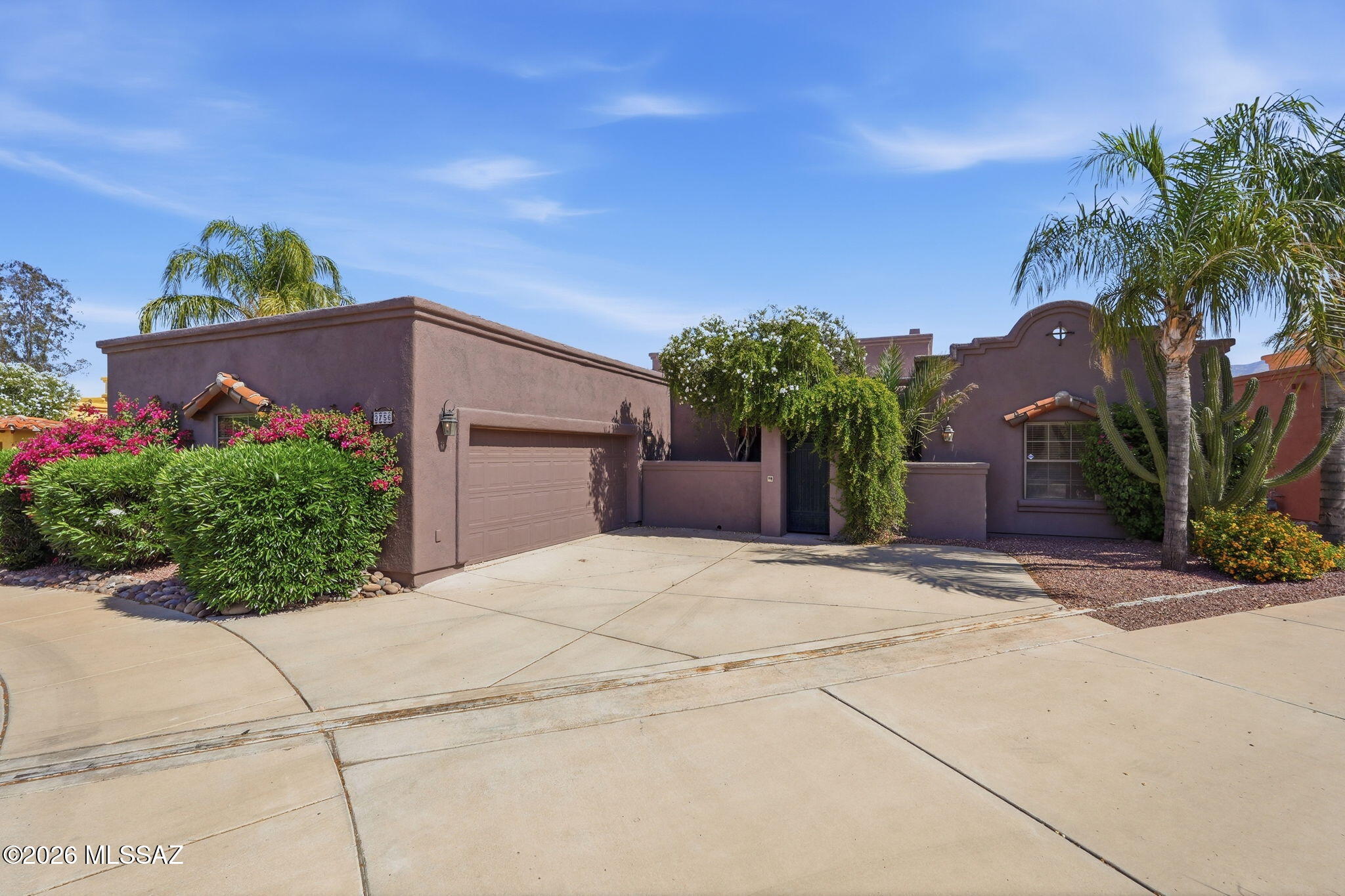 Welcome to this stunning 4-bedroom, 3-bath Santa Fe-style home in the gated Rancho Reposo community! Built in 2004, this single-story residence offers 2,090 sq ft of beautifully designed living space featuring a spacious great room with beamed ceilings, a gas fireplace, and polished concrete floors. The kitchen shines with granite tile countertops, stainless appliances, a walk-in pantry, and an island perfect for entertaining. Enjoy a serene backyard with desert landscaping, mature trees, and a covered patio. Located on a quiet cul-de-sac with north/south exposure, this home includes a 2-car garage and easy access to shopping, dining, and the University of Arizona.