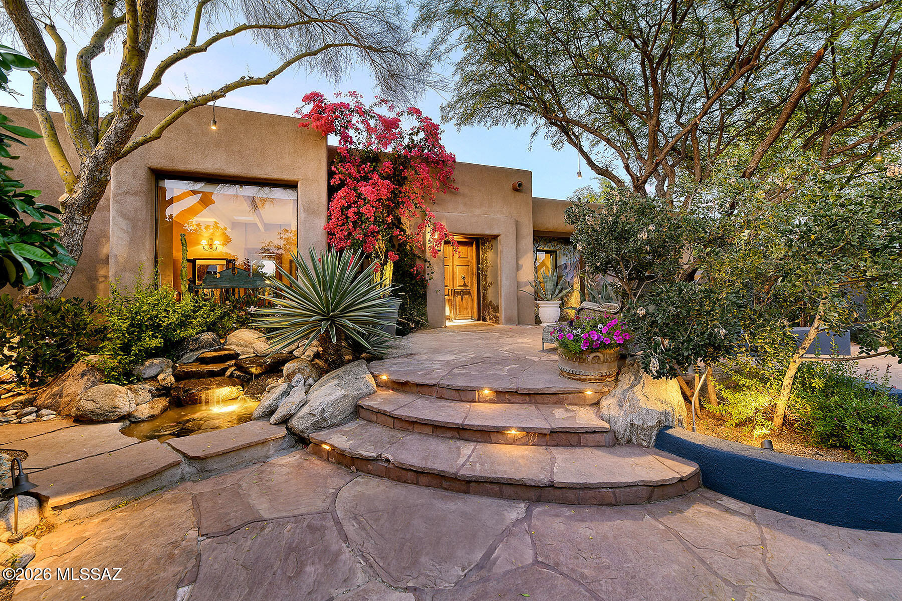 Experience timeless elegance in this stunning 4,266 sq. ft., 4-bedroom Southwestern masterpiece ideally located in the central Catalina Foothills of Tucson.  Enter this all masonry stucco home through a historic wrought iron gate into a truly enchanting, landscape architect-designed front courtyard, complete with a bubbling fountain, firepit, flagstone and scored concrete surfaces, and a covered patio featuring an authentic ocotillo ceiling. A hand-painted mural of Finger Rock adds a distinctive artistic touch, setting the tone for what lies beyond.  A covered entry and historic front door welcome you into a warm and inviting foyer, highlighted by antique cabinetry and custom library shelving that seamlessly transition into the expansive living area. The living room showcases classic Southwestern charm with its beamed and planked ceilings, cozy fireplace, and an adjoining gourmet kitchen. Designed for both beauty and function, the kitchen features a center island, soapstone counters, custom cabinetry and stainless steel designer appliances.  Adjoining the kitchen is the equally impressive dining room, with exposed beams and dramatic collapsing glass doors that open effortlessly to the rear patio, perfect for indoor-outdoor entertaining. The gracious primary suite offers a serene retreat with generous closet space and dual vanities. A flexible fourth bedroom serves beautifully as a guest suite or private office, and don't miss the additional spacious 13' x 18' den or office.  Step outside to a resort-style backyard oasis that exudes charm and tranquility. Enjoy cantera stone floors, a beamed patio ceiling, outdoor fireplace, cascading waterfall, sparkling pool and spa, and even an outdoor shower. Additional thoughtfully designed porches, patios, and walkways complete this extraordinary property.  If you are seeking authentic Southwestern character, charm, and refined elegance, this exceptional home delivers it all.