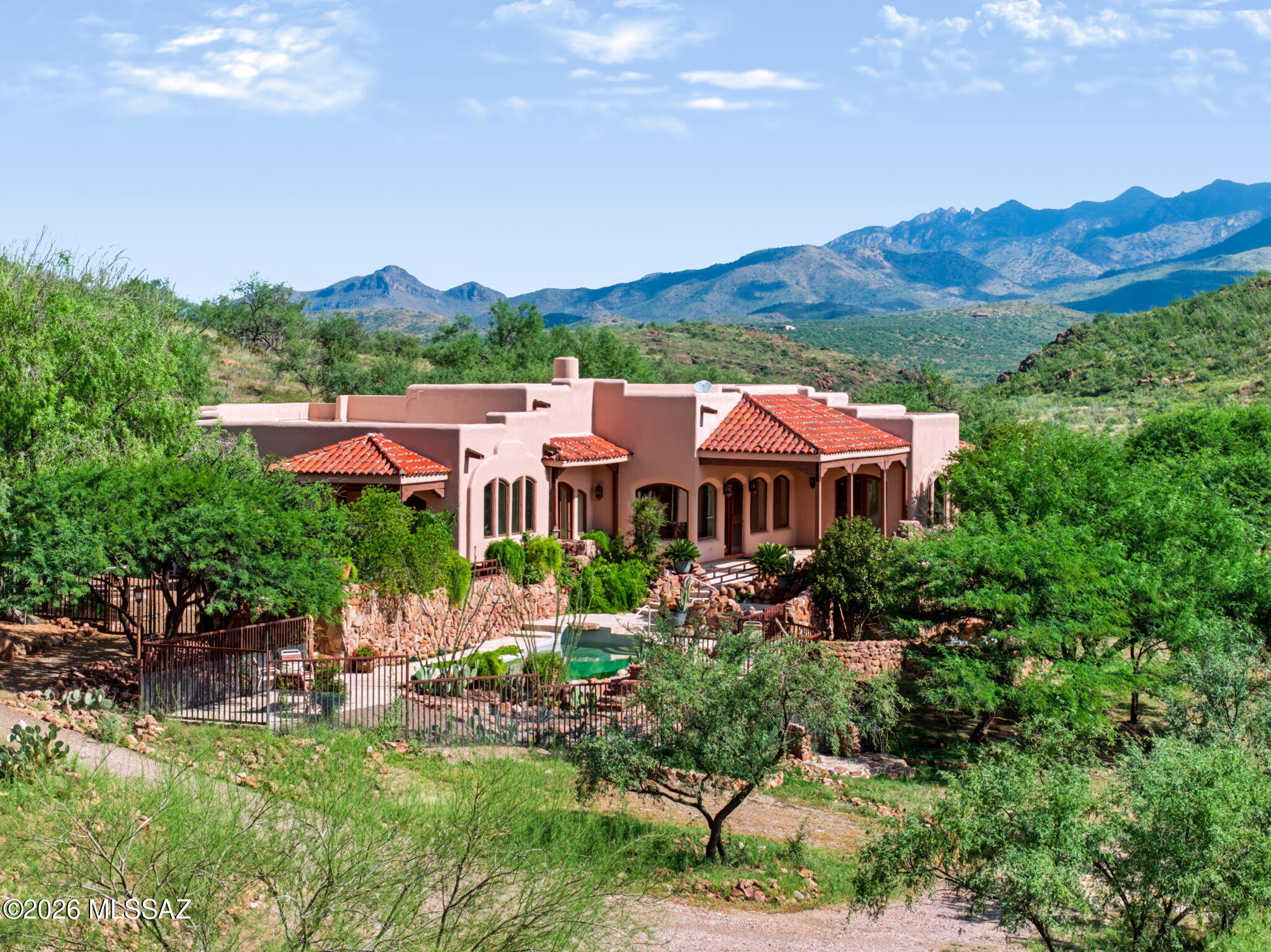 This home was one of the first houses built on Morningstar Ranch as a custom home for the developer. The architectural design focuses on the arched windows and double front doors which fill the house with light and frame incredible views. Everything is artistically unique from the hand forged metal hardware to the travertine tile in the kitchen and main bedroom. The great room with its hardwood floors, massive beams, 13 foot ceilings, and huge stone fireplace create a filling of rustic elegance. The outside spaces frame the panoramic views with four large covered porches and patios, two water features, a pool and spa all set in mature Landscaping. A separate 1100 square-foot Casita with two bedrooms and two bathrooms provides guests and family with accommodations to share this incredible ranch set on 97 acres of open space. There is also a separate four car garage/workshop that is down the slope from the main home. This provides plenty of space for extra vehicles and storage. This is truly a very special property. The 97 acres are split between two separate building/tax lots. So you have the opportunity to sell a lot or even build another residence.