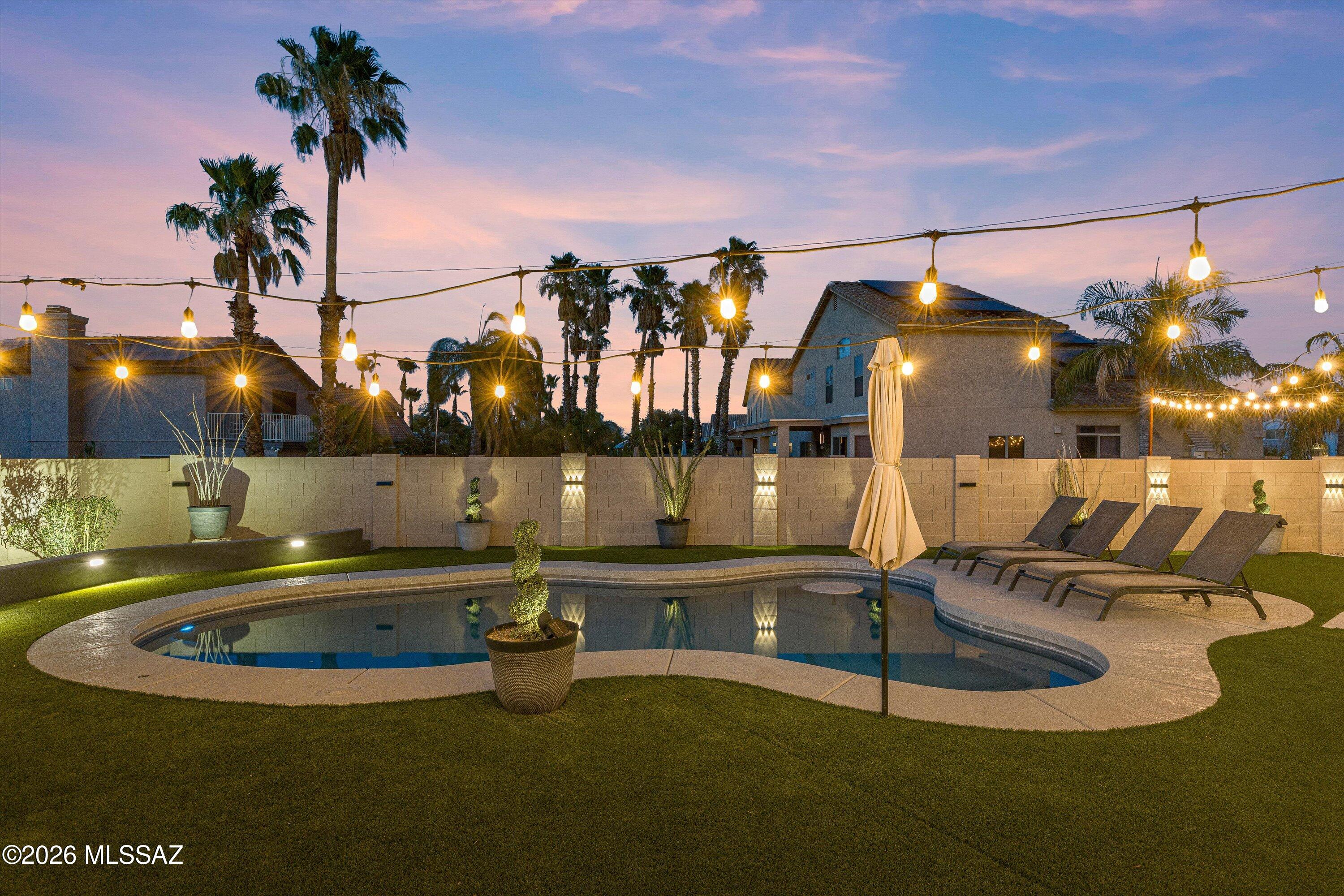 What if your home felt like a private resort? What if pulling the truck into your private 3-car garage was part of the daily routine? Taking a dip in the pool, placing a cool beverage on the round swim-up table beneath the shade of an umbrella: these were activities most only access while on vacation. Here, you can live it on-demand. The backyard speaks like the patio of your favorite restaurant: string lights illuminating in just the right places, and a gazebo that frames the views of Sombrero Peak to the West. A mature mesquite tree protects the front of the home from the heat of the afternoon sun. Shade like that can't be grown overnight, but it can be bought. One of the 6 bedrooms is on the main level, convenient for guests or maybe it's a home-gym or office. Smart uses of the space, like the beverage fridge built into the under-stairs, and the large pantry that occupies the other void. Bright bougainvillea frame the formal dining room windows, currently being used as a casual eating nook while your friends shoot some pool. Whether you're relocating in-town or coming in from out of state, stepping inside this house will feel like home. Buyer to verify all facts + figures, including those in MLS.