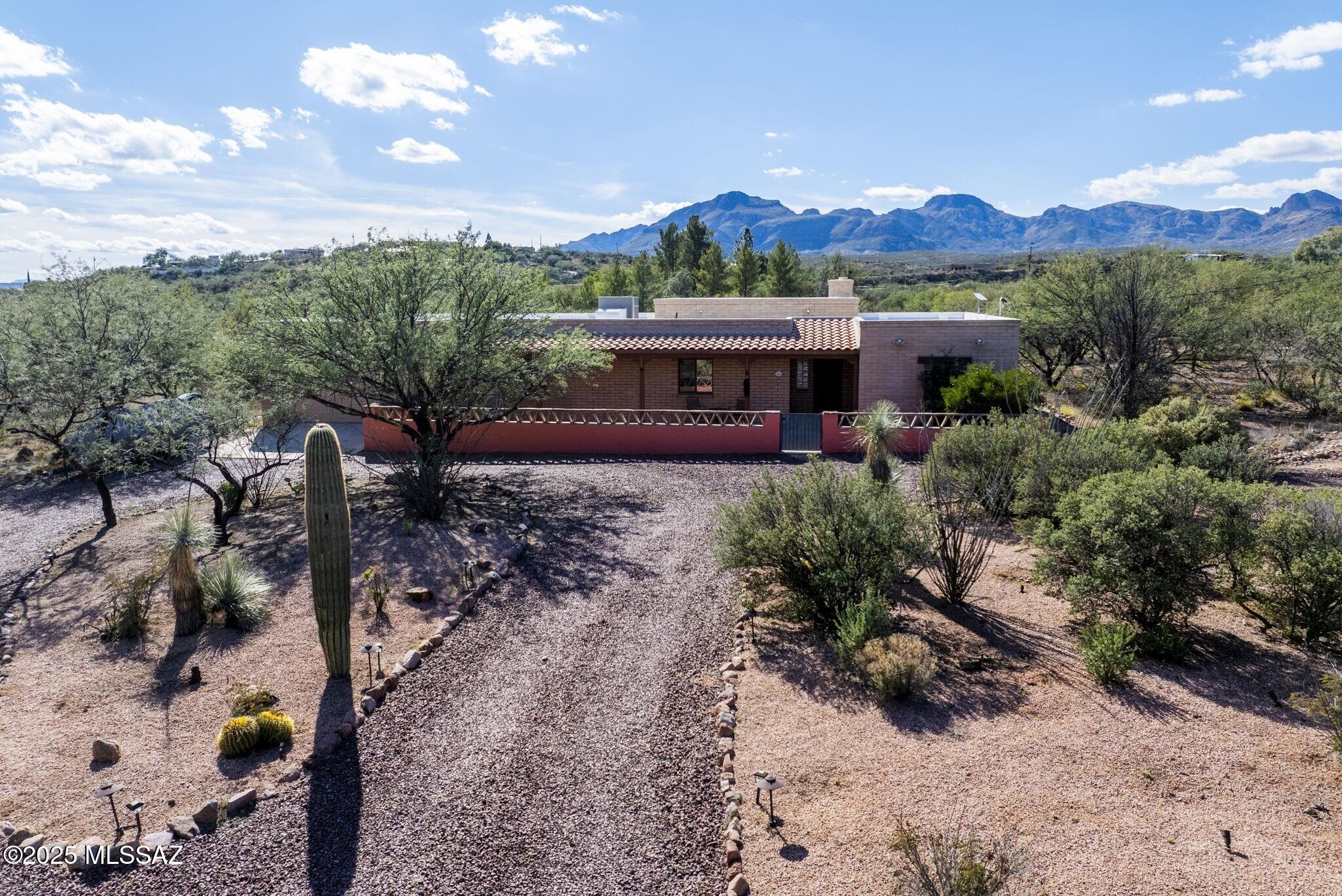 Nestled on a little over an acre with no HOA to limit your vision, this 3-bedroom, 2-bath home gives you the kind of flexibility that's hard to find. The setting is classic Tubac with open sky, mountain views that don't quit, and enough open space around you to feel private without feeling remote. Exterior spaces offer room for gardening, hiking and hobbies, with walled courtyard and plenty of covered hardscape for al fresco dining and entertaining. Sheltered entrance opens into an expansive interior filled with warm, natural lighting. Design details include exposed beam ceilings, tile and hardwood flooring, kiva-style fireplace, built-in bookshelves and an open-concept floorplan. Generous kitchen features a seated bar for casual dining, upgraded appliances and dedicated office space.