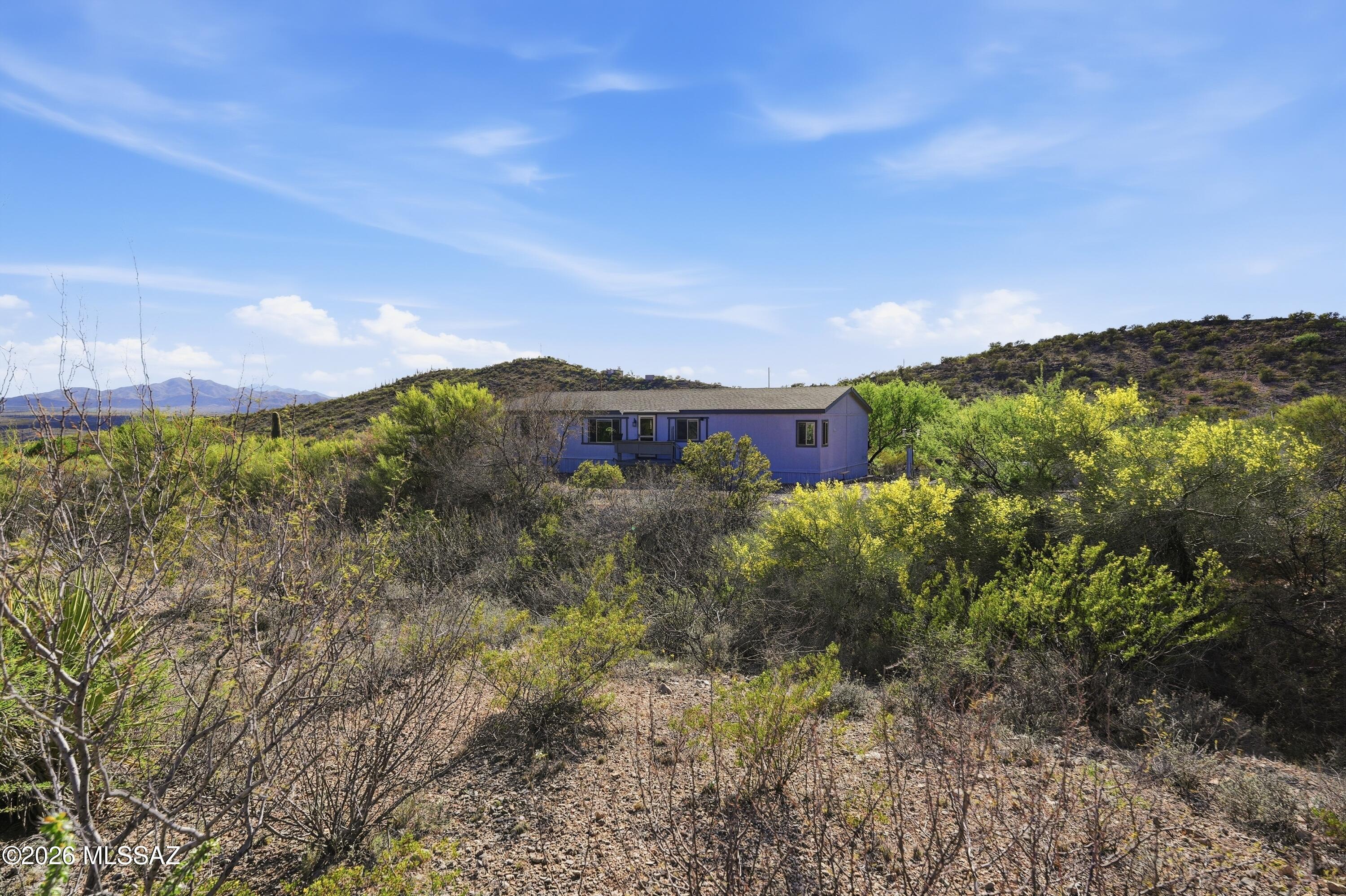 Welcome home to your own private slice of the Sonoran Desert, where wide open skies, mountain views, and true Arizona living come together on over 4 acres of possibility. Tucked on a quiet dirt road, this property offers the rare combination of peaceful seclusion and everyday convenience, giving you the space to breathe while still being just minutes from I-10, shopping, dining, and local attractions. Thoughtful updates featuring brand-new Milgard windows throughout, bring in natural light and showcase the surrounding desert landscape from nearly every room, remote operated blinds, refreshed lighting/fans and bathrooms, including beautifully upgraded flooring, vanities, mirrors, lighting and faucets. The flexible floor plan offers multiple living areas, perfect for a home office, creative space, or simply room to spread out. The kitchen is functional and inviting, complete with ample cabinet and counter space, a large pantry, and a full suite of stainless-steel appliances.
Outside is where this property truly shines. With 4.26 acres, the possibilities are endless; bring your animals, start a garden, build a workshop, store your toys, or simply enjoy the privacy and quiet. A double gate provides easy access for vehicles, while two storage sheds offer space for hobbies or equipment. The front yard features a charming citrus and cactus garden, including a unique fruit cocktail tree producing lemons, oranges, and ruby red grapefruit. This is more than a home; it's a lifestyle. Whether you're watching the sunrise over the mountains, enjoying the stillness of the desert, or creating the space you've always envisioned, this property offers the freedom to live life your way. Not remote, just private. Your desert retreat awaits.