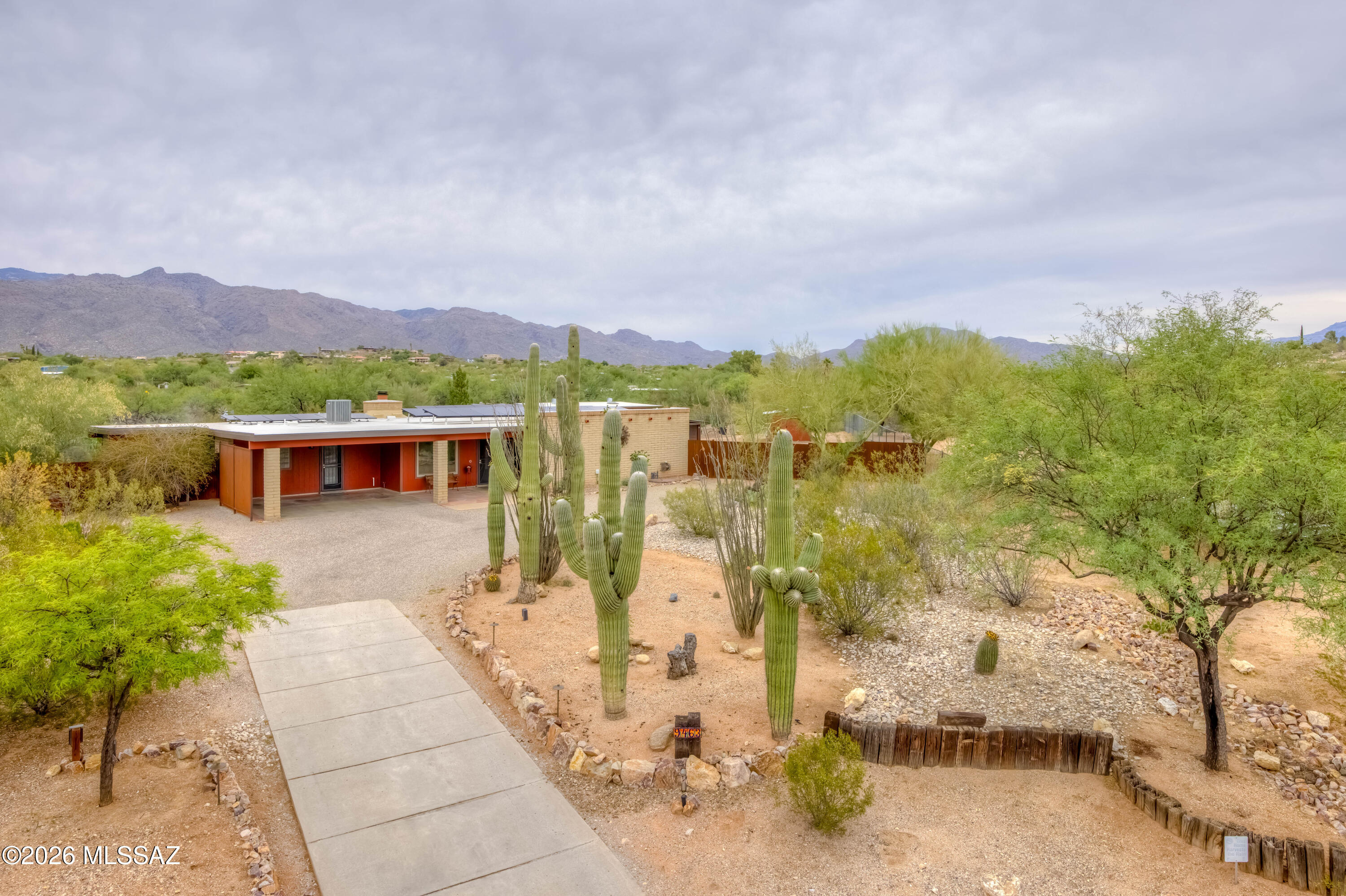 Nestled just off Catalina Highway in Tucson's sought-after northeast area, this ranch-style home sits on nearly an acre. Surrounded by stunning natural vegetation, including Saguaro Cacti Palo Verde and Mesquite trees, which offers a serene retreat. The spacious rear patio boasts breathtaking mountain views, an outdoor kitchen, and custom power shades. Additional features include a rain harvesting system and owned solar panels with new batteries. Outbuildings comprise a workshop with a new mini-split system, Conex storage unit, and extra storage hut for all your toys, gardening tools and firewood. Low voltage lighting throughout property and small corral for your horse, all accessible through custom metal gates. Newer HVAC, Water Softener, Roof Recoated, Don't miss this rare opportunity!