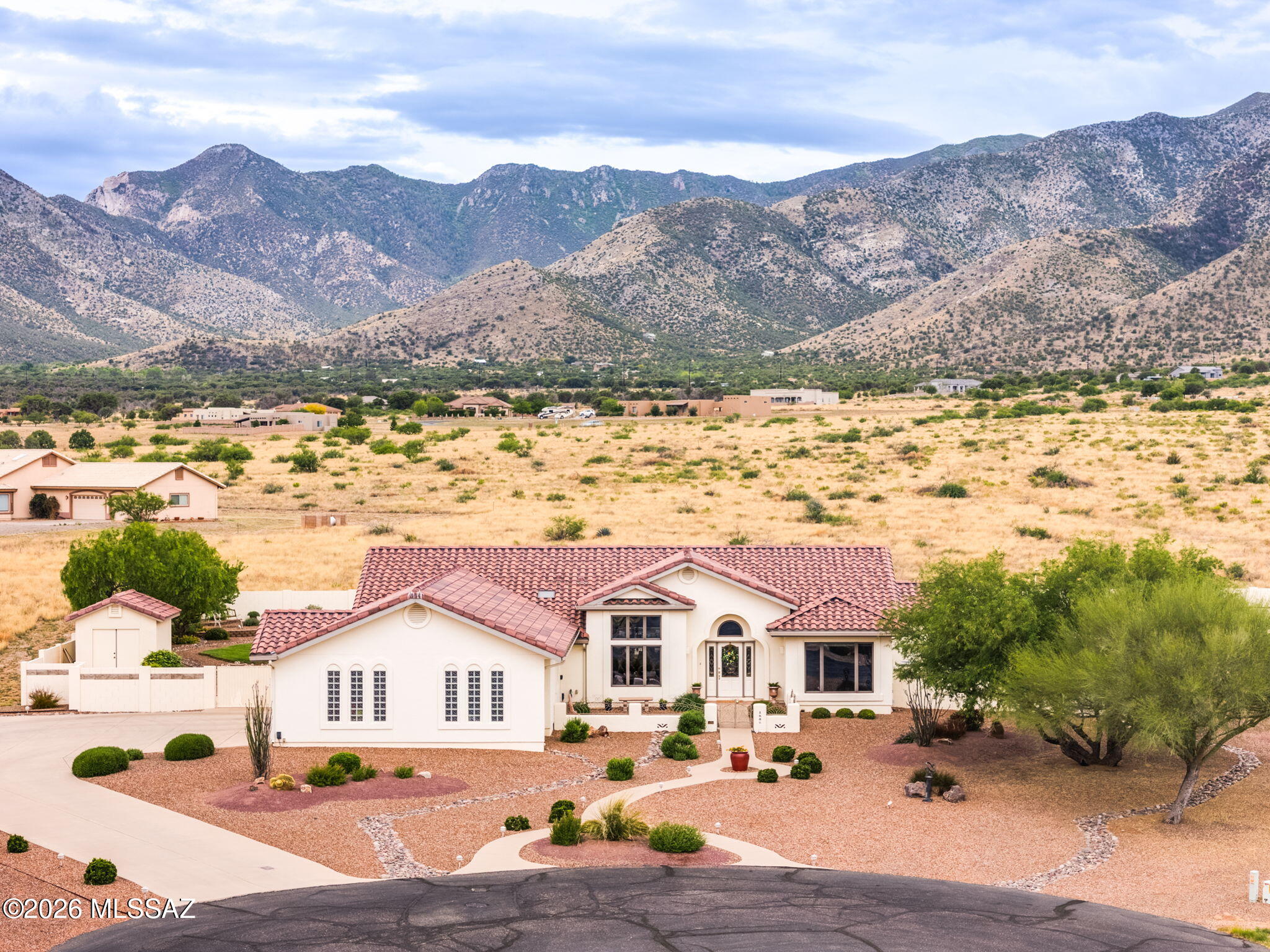 Experience elevated desert living in this exceptional custom-built Cunningham masterpiece, proudly offered by the original owners. This luxurious 3-bed, 2-bath residence with a private office blends timeless craftsmanship with refined elegance and upscale comfort at every turn.
Designed for both entertaining and serene relaxation, the resort-inspired backyard is nothing short of spectacular: featuring a sparkling heated Pebble Tec pool, cascading waterfall, soothing spa, and a fully appointed outdoor kitchen with built-in BBQ, all perfectly positioned to capture breathtaking Huachuca Mountain views. Inside, a gourmet kitchen is the heart of the home, while the oversized garage and thoughtfully designed layout offer both functionality and comfort. Rare opportunity to own this Arizona gem!