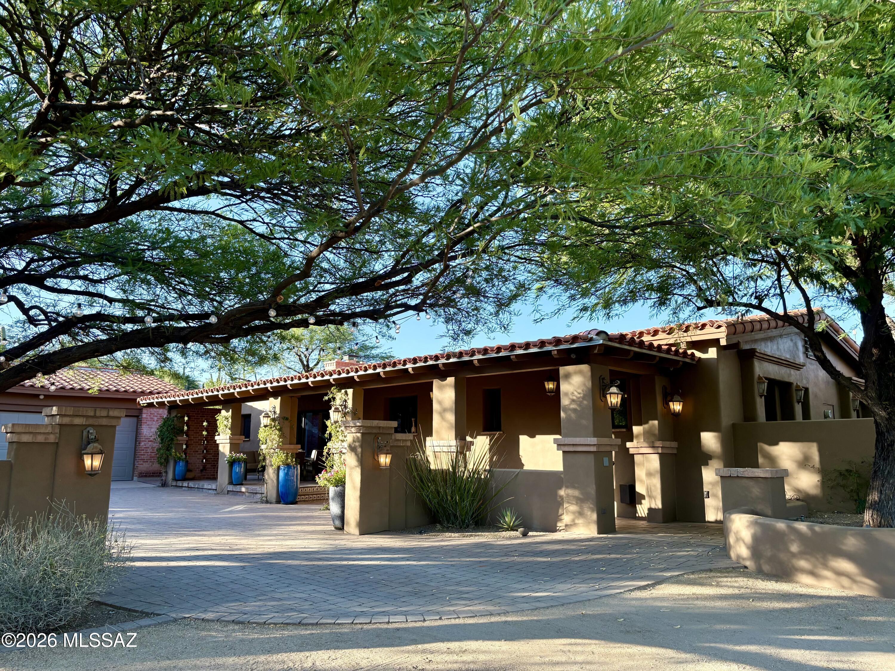 Tucked into the historic neighborhood of Catalina Foothills Estates is this serene Hacienda style home w/high exposed wood beamed ceilings, decorative doorways, modern concrete floors throughout, remodeled chefs kitchen w/butlers pantry, ample outdoor entertaining areas & so much more. This home is a blend of views, nature, comfortable luxury living, natural light & an outdoor paradise.  Enter through a courtyard w/fountain at the entrance, onto a front veranda into the home where you'll find high wood beamed ceilings, fireplace and large living/dining room.  Kitchen is open w/high ceilings, huge island, 2 sinks, gas range, subzero fridge, overlooking the family room/fireplace & adjacent to the butlers pantry w/additional dishwasher, beverage drawer & 100 bottle wine fridge. Primary Suite w/fireplace, huge walk in closet, bathroom has dual sinks, jetted tub & separate shower w/steam shower feature. Outside beautiful pebble tec pool w/natural stone & pavers surround, gas fire-pit, artificial turf, Sport Court for basketball / pickle ball, a Casita w/bathroom for guest use or gym, numerous outdoor entertaining areas w/Mountain Views & 2 car detached garage features an electric car charger & storage.  This property has sought after Catalina Foothills Schools, close to hiking trails, biking, premier shopping, restaurants, & just 15 mins to downtown & UA. This home truly has it all