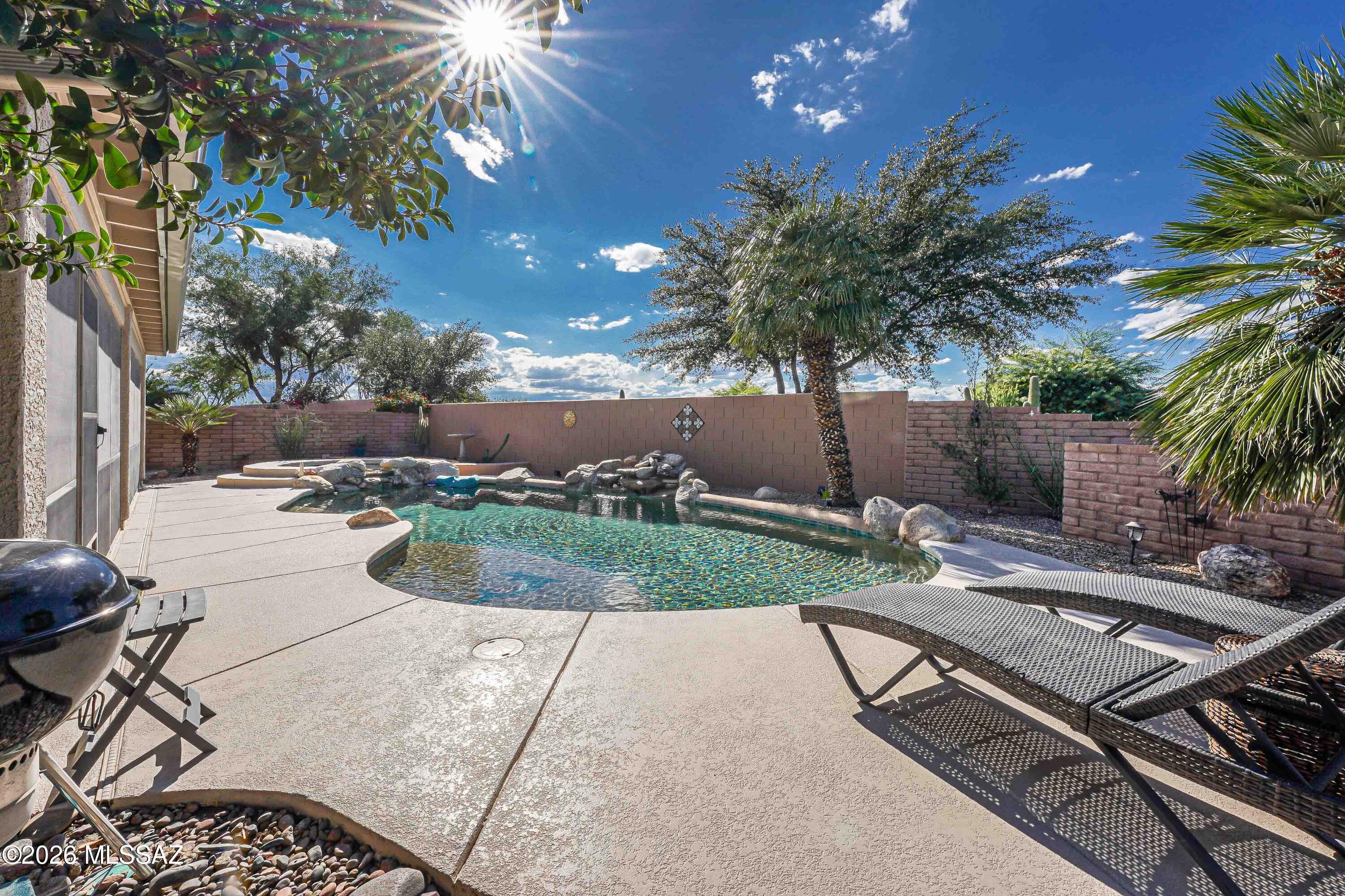 YOUR RESORT LIFESTYLE AWAITS IN QUAIL CREEK! Relax by your sparkling pool, unwind in the spa, and enjoy the ease of living in this sought-after active adult community! An owned solar system offers energy savings, while a spacious 2-car garage plus a dedicated golf cart garage complements the Quail Creek lifestyle. Set on a desirable corner lot with no rear neighbor, this home also offers peace of mind with roof underlayment replaced just 4 years ago, a 7-year-old HVAC system, and a termite warranty. A welcoming courtyard sets the stage for this light-filled, expanded Laredo. Inside, the spacious great room with engineered wood floors flows seamlessly into the kitchen and dining area, creating an inviting setting for everyday living and entertaining. The kitchen features quartz countertops, stainless-steel appliances, a convection oven, an island, and a breakfast bar perfect for morning coffee. Abundant windows fill the dining area with natural light. The owner's suite offers a bay window, generous walk-in closet, and an en-suite bathroom with dual vanities and a walk-in shower. A desirable split-bedroom layout provides privacy for you and your guests, while the den, with double doors and a built-in desk, is ideal for a home office or hobby room. Step outside and let the relaxation begin! The screened porch is a comfortable spot to enjoy Arizona afternoons, while the beautiful private pool with waterfall and spa invite you to unwind in your own backyard oasis. Mature landscaping and a low-maintenance yard complete the outdoor setting.Beautifully maintained, this property is one you won't want to miss!