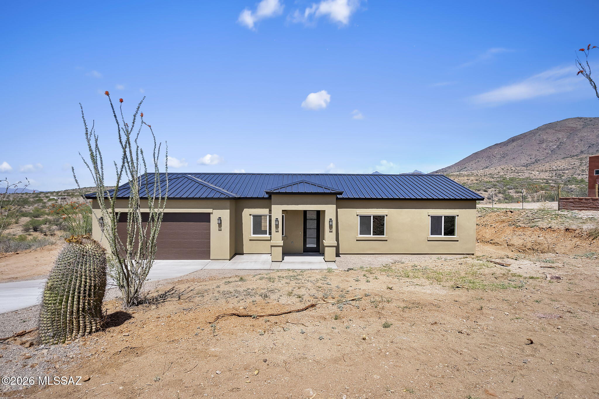 Welcome to your private desert retreat at 1678 Avenida Calamar in Rio Rico, Arizona. Where modern ranch design meets breathtaking natural beauty. Situated on a spacious and highly usable 0.46-acre lot, this newly built home captures extraordinary mountain views and unforgettable Arizona sunsets. Designed with both style and functionality in mind, the home features a striking metal roof and durable synthetic stucco exterior. Step inside to an open-concept floor plan enhanced by high ceilings, abundant natural light, and wood-plank ceramic tile flooring that flows seamlessly throughout. The custom kitchen is the centerpiece of the home, showcasing quartz countertops, stainless steel appliances, modern lighting, and quality cabinetry with soft-close hinges perfect for both everyday living and entertaining. The primary suite offers a peaceful escape, complete with a walk-in closet, dual vanity, and a spacious walk-in shower. Elegant French doors provide direct access to the outdoors, inviting you to enjoy the tranquil surroundings at any time of day. Set in a quiet and private location surrounded by serene desert landscape, this property delivers both seclusion and convenience with easy access to the Palo Parado exit. Experience the perfect blend of modern comfort, thoughtful design, and scenic beauty this is desert living at its finest.