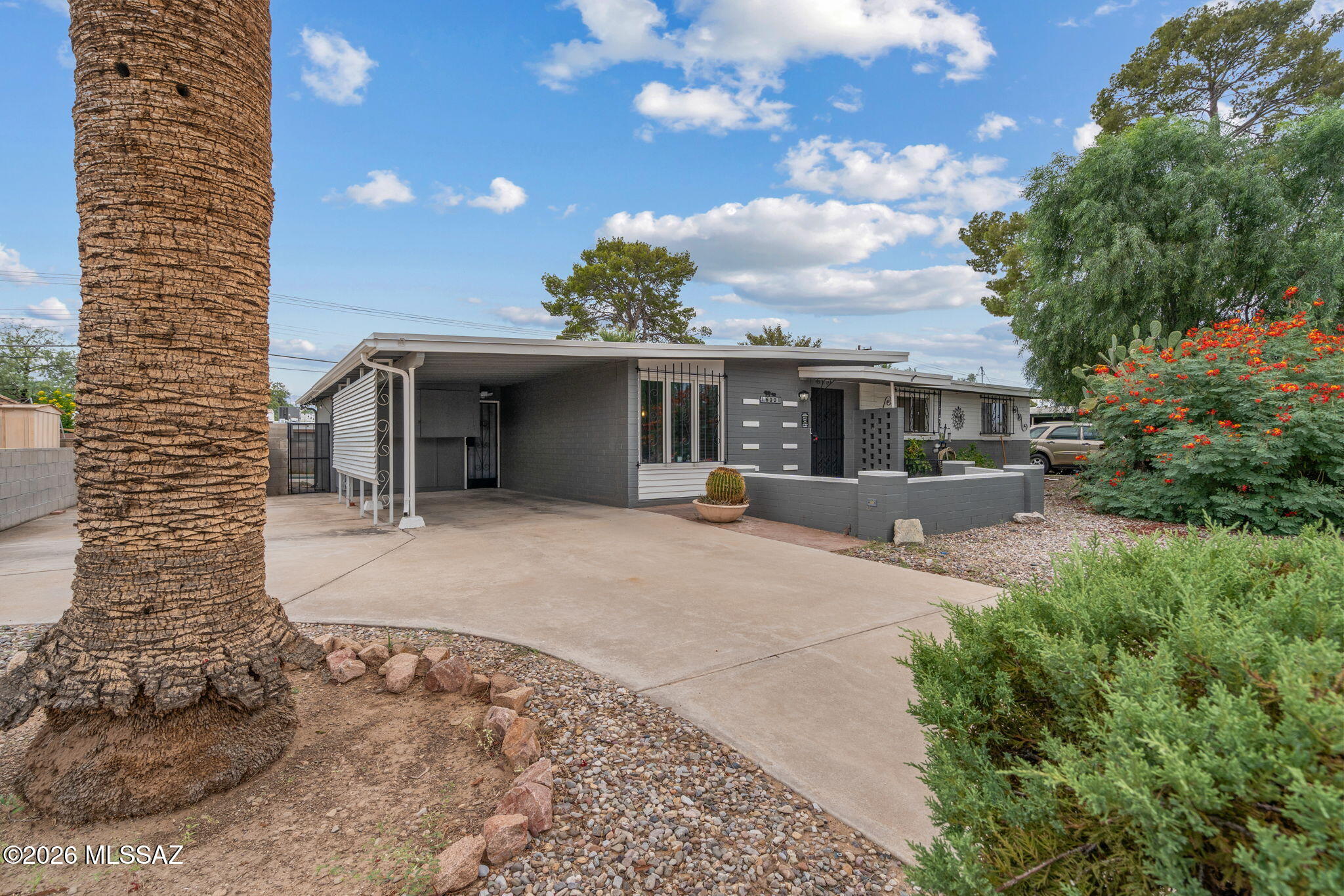 Midcentury character meets relaxed Tucson living in this 3-bedroom, 2-bath home, cared for by just two families since it was built. Inside, a distinctive fireplace, warm tile floors, and separate living and family rooms create inviting spaces to gather or unwind. The hall bath retains its original tile, while the primary bath features an updated shower and cabinetry. Outside, mature landscaping, a covered patio, and a freeform pool create a private-feeling retreat. Centrally located with convenient access to Davis-Monthan AFB and everyday amenities.