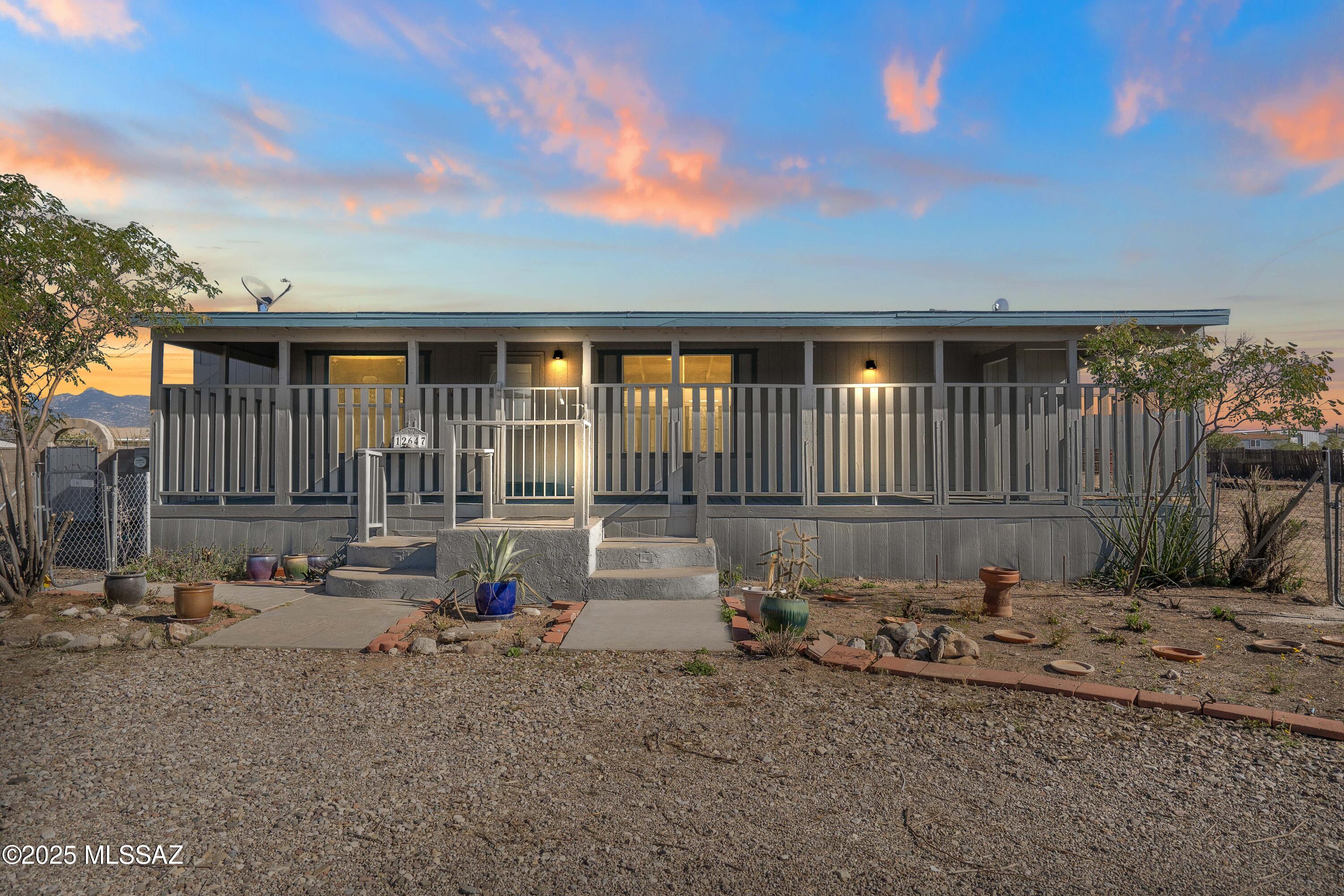 Serene, tranquil living on a fully usable acre just minutes from I-10. This 3-bedroom, 2-bath home offers wide-open desert views and space to create the lifestyle you want. Freshly painted inside and out, with new carpet in the guest bedrooms, it features a layout that separates the primary suite and formal living area from the guest bedrooms and main living spaces.
Located in the award-winning Vail School District. The full-length front porch is ideal for relaxing mornings and evening breezes. The backyard includes a separate fenced enclosure for storage or projects, plus a recently added sturdy carport for covered parking or a versatile workspace.