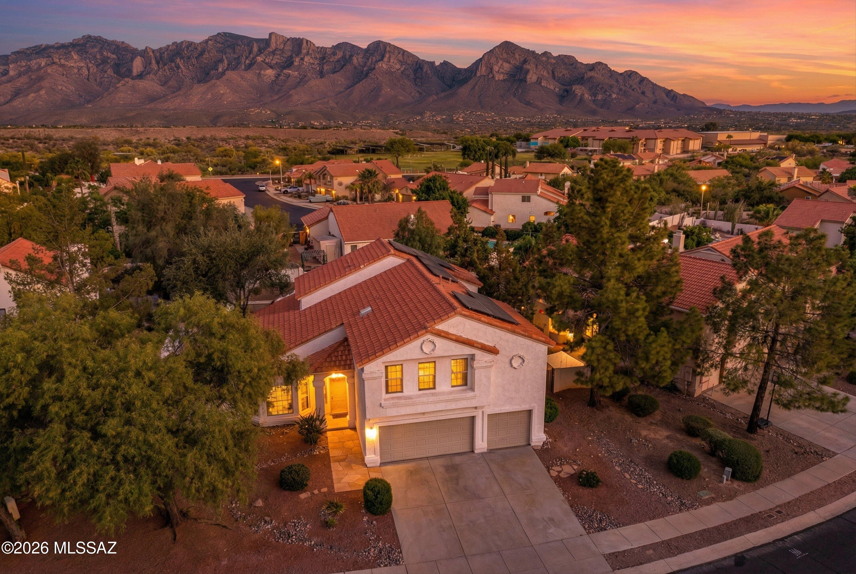 Welcome to this beautifully updated home in Oro Valley's highly sought-after Copper Creek community. Offering 5 bedrooms, 3 bathrooms, and 2,920 square feet of thoughtfully designed living space, this residence features a versatile and inviting floor plan with separate living, dining, and family rooms--perfect for both everyday living and entertaining. The family room is anchored by a cozy fireplace, creating a warm and welcoming atmosphere. The spacious kitchen is a true centerpiece, complete with abundant cabinetry and counter space, a convenient breakfast bar, and a walk-in pantry. The expansive primary suite is a private retreat, featuring a separate sitting area, a private balcony with stunning views, a luxurious en-suite bathroom with separate shower and soaking tub, and a large..... ....walk-in closet. Upstairs, you'll find three additional guest bedrooms with a shared hall bath, while a fifth bedroom and full bathroom downstairs provide ideal space for guests or multi-generational living. Recent upgrades include PEX plumbing (no poly pipes), new interior paint, new carpet and flooring, and updated bathroom and lighting fixtures throughout. Step outside to enjoy the beautifully landscaped backyard, complete with a large covered patio, a sparkling fenced pool, and scenic views--perfect for relaxing or entertaining. Home has OWNED SOLAR system, perfect for lower utility costs! Additional highlights include a finished and freshly painted 3-car garage with brand-new doors and openers. This move-in-ready home combines comfort, style, and functionality in one exceptional package.