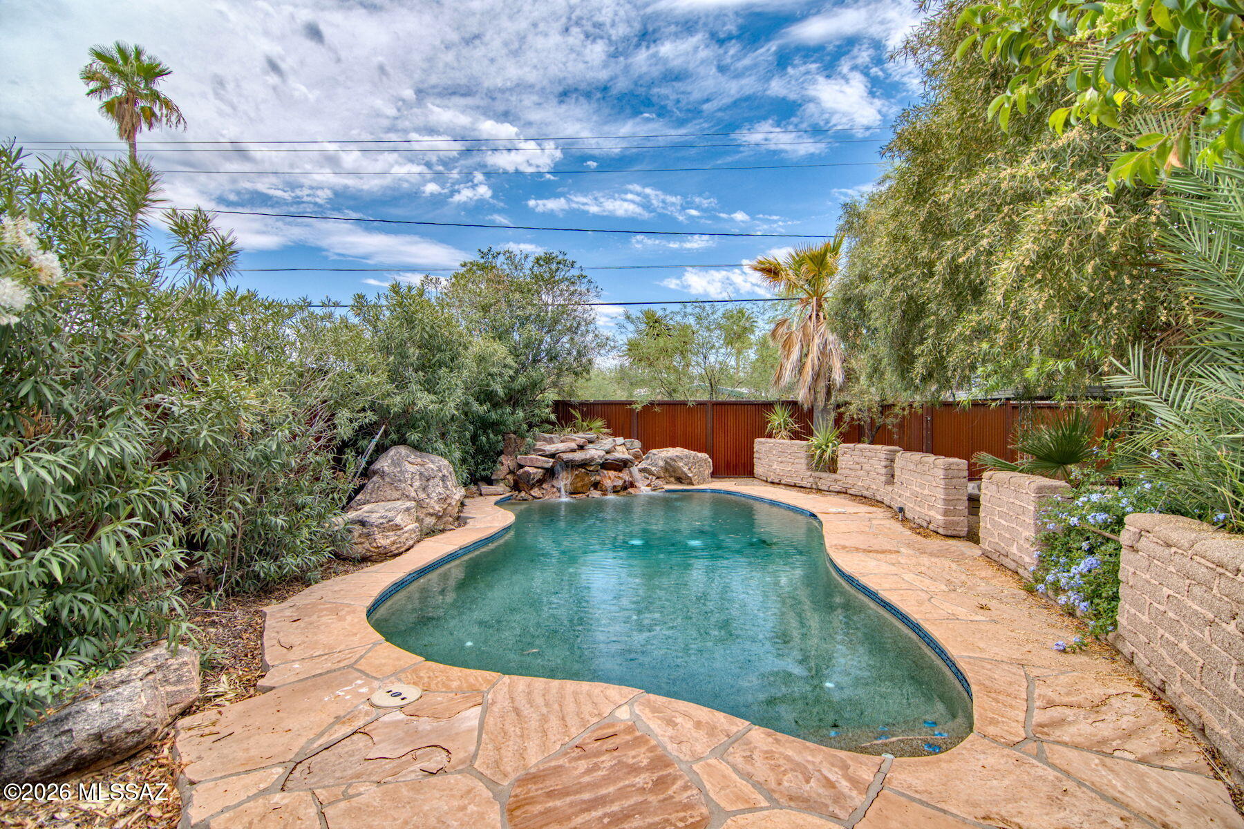 Price range $650,000 - $675,000. A Rare Dual-Purpose Gem in Historic Catalina Vista Step onto this property and the traffic noise disappears, a peaceful sanctuary from the moment you arrive. Whether you're searching for a dream primary residence or a high-performing short-term rental investment, this iconic 1946 territorial-style home in coveted Catalina Vista delivers both effortlessly. The impressive adobe perimeter wall and striking Cor-Ten steel entry gate do more than impress, they create a natural sound barrier that filters out city traffic and street noise, surrounding the property in a private oasis. The sculpted front yard features towering saguaros, native desert boulders, and a thoughtfully designed flood basin landscape that channels rainwater directly to the plantings. A low-maintenance, sustainable Sonoran desert masterpiece that sets the tone for everything inside.

For the Airbnb Investor: This home was practically designed for short-term rental success. The 2024 addition introduced a luxurious primary suite, completing a true split bedroom floor plan that gives guests and hosts complete privacy on opposite ends of the home. Dual access points on both sides of the property allow for seamless, independent guest entry -- no awkward shared spaces, just a smooth, professional hosting experience. The Pebbletec pool with waterfall feature and lush tropical backyard? That's your five-star listing photo. And the large gravel side yard with full RV hookups adds a second income stream -- rent the RV space separately and let the property pay for itself.

For the Primary Homeowner: This is the kind of home Tucson rarely offers. Original 1946 territorial character meets thoughtful 2024 craftsmanship -- matching masonry stucco, wall-to-wall porcelain tile, designer bathrooms, a gourmet kitchen with Corian countertops and a charming built-in dining nook, and three independent climate zones for year-round comfort. Two skylights bring natural light into the most intimate spaces, while mature trees, flowering hedges, and a covered patio frame a backyard that feels like a private resort.

The detached stucco workshop with full electricity and a security-gated entry round out a property that is as functional as it is beautiful.

Historic charm. Modern upgrades. Income potential. Privacy you can feel. This is not just a home -- it's a lifestyle and an investment in one.