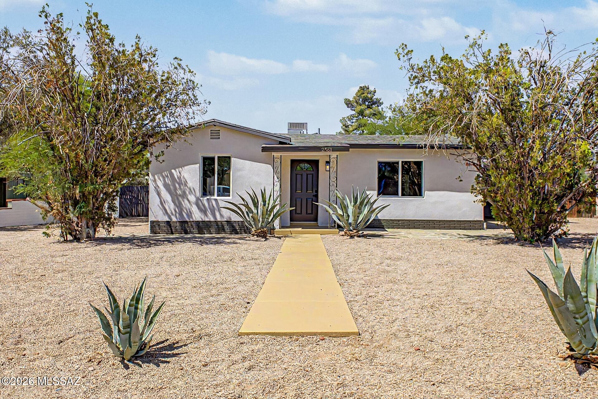 Adorable home near La Madera Park & popular dining spots! A low-care front yard w/desert plantings, gravel driveway, RV gate, & carport spaces set the tone. The immaculate interior welcomes you w/ vaulted ceilings, recessed lighting, ceiling fans, wood-look flooring, neutral paint, & thick baseboards. Modern kitchen offers sought-after white cabinetry, SS appliances, a center breakfast bar island, & generous counters. You'll love the bright family room for relaxation or hosting guests! Retreat to the cozy primary bedroom boasting a spacious closet & an elegant bathroom w/dual sinks & tiled shower. Outdoors, the easy-care backyard offers shade trees, plenty of room to enjoy Arizona's sunshine, & a detached garage w/workshop area for hobbies, storage or projects. Move-in ready! Agent/Owner