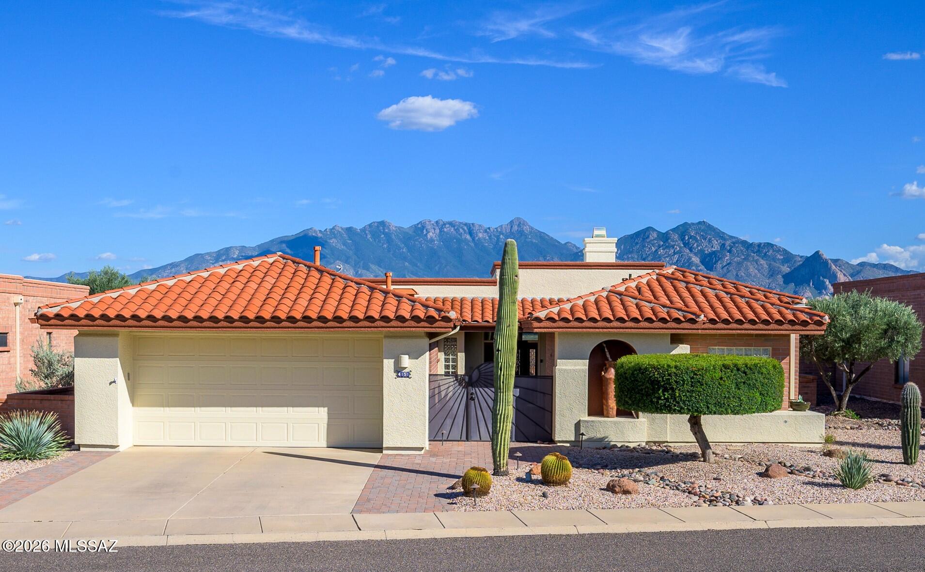 Experience a remarkable blend of comfort and breathtaking scenery in this impeccably maintained retirement home, ideally situated for those who appreciate sweeping views of the Santa Rita Mountains. Upon arrival, the distinguished red tile roof and thoughtfully designed desert landscaping welcome you into a charming courtyard, establishing a warm and inviting atmosphere.   Step through the front door, and you'll immediately notice large windows that frame spectacular mountain vistas, allowing natural light to fill the living space and provide a constantly evolving backdrop. The kitchen is ideal for culinary enthusiasts, with pristine white cabinetry, abundant storage, Corian countertops, and a center island.  The adjacent family room and dining area facilitate seamless interaction while preparing meals. The two bedrooms are thoughtfully positioned on opposite sides of the home to maximize privacy. The expansive primary suite is a true retreat, complete with a dual-sink vanity, a luxurious jetted tub, a doorless walk-in shower, and a custom closet, all designed for ultimate convenience. Additionally, the custom office extension, equipped with cherry cabinetry, is well-suited for hobbies or computer tasks.  Outdoor living is elevated by a recently expanded brick patio, complete with electronic screens to create a private retreat. Whether you're enjoying a sunrise coffee or an evening cocktail, the 180-degree mountain panoramas and dynamic, ever-changing desert skies provide a stunning backdrop. With every detail lovingly cared for, this is retirement living at its finest!