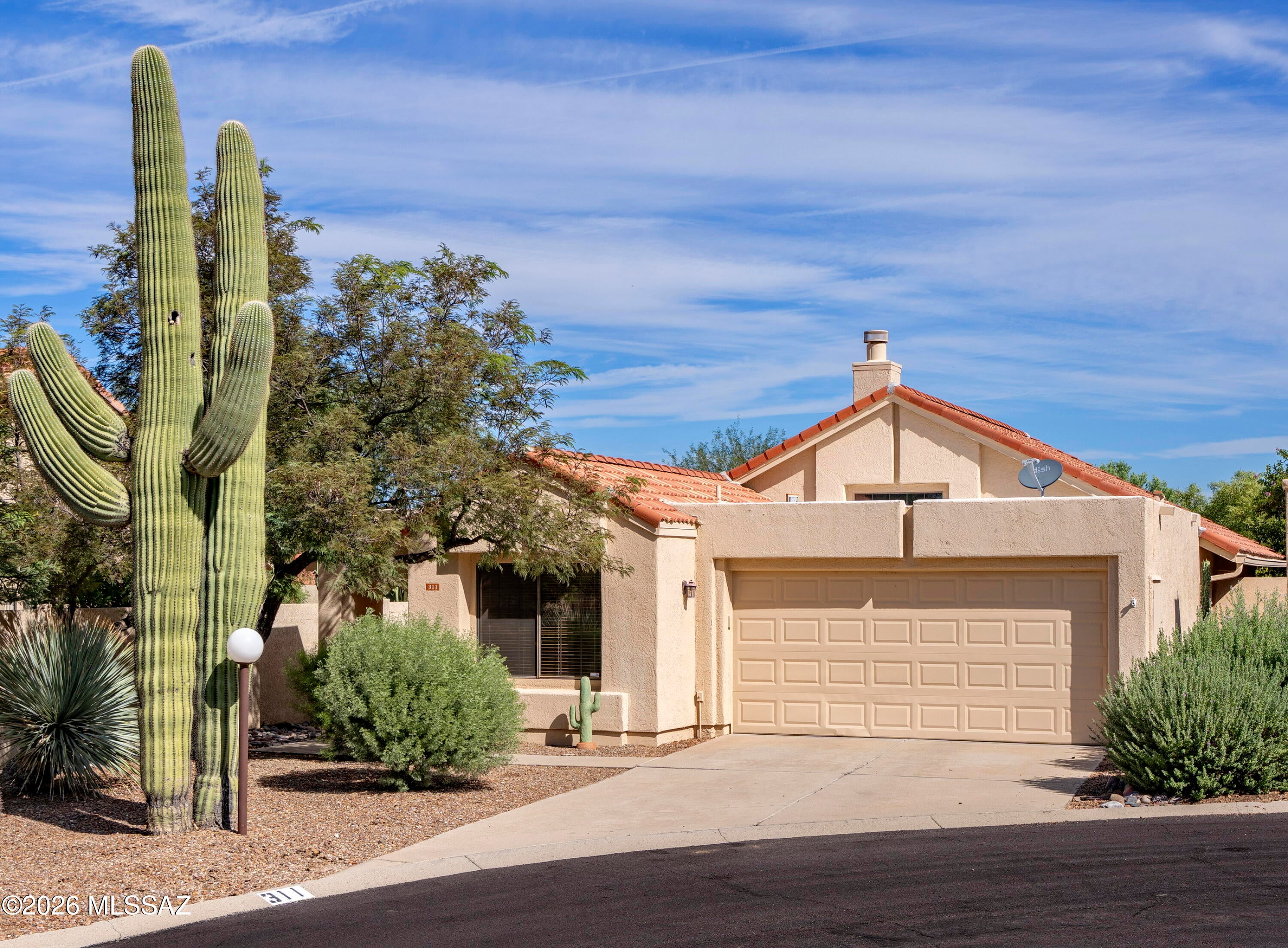 Walk out of your front door and gaze at the Catalina Mountains! Nestled on a cul-de-sac in the popular patio home community of Villa Balboa in Oro Valley, this two bedroom, two bath is ready to enjoy this fall and winter season.  A delightful part-time, year-round or investment property, your new home is a well-laid out 1237 square feet with a split-bedroom floorplan. The large open living/ dining space features attractive architectural details--a soaring ceiling with a clerestory window, a plant ledge and a fireplace with a slate mantel and facade. With a sliding glass door to the private outdoor space, the kitchen offers all stainless steel appliances, including a smooth top, slide-in electric range. A corner undermounted graphite sink is flanked with windows overlooking the outdoor space and a counter-level window adds interest and task lighting. The kitchen also features granite counters with a breakfast bar for in-kitchen dining, a pantry and the laundry closet, complete with washer and dryer. Featuring a slider to the patio, the private primary suite has a walk-in closet and a bath with dual sinks, granite counters and a jetted tub/shower combo with a fully tiled surround. A generous guest bedroom at the front of the home is serviced by a hall bath with a beautifully tiled walk-in shower. There is tile throughout this home except for the bamboo floors in both bedrooms and all rooms have ceiling fans. The attached two car garage has an access door to the inside of the home and one to the side yard for added convenience.  The private outdoor space is fully walled and is ready for your touches with a brick patio that wraps around the side of the home, mature plantings and banco seating.  The front yard is also low-care and boasts mature plantings and a view of Pusch Ridge. Adjacent to the historic Oro Valley Country Club, your new neighborhood also has a community pool and spa. With easy access to Oracle Road as well as the popular 131-mile multi-use "Loop", getting around is a breeze. Your new home is located mere moments to the soon to be reimagined and rebranded Oro Valley Village Center (complete with shopping, dining, and movie theaters), the Oro Valley Library, Catalina State Park, Town Hall, The Oro Valley Farmers Market at Steam Pump Village, and an array of different shopping and dining options (some under five minutes away!).