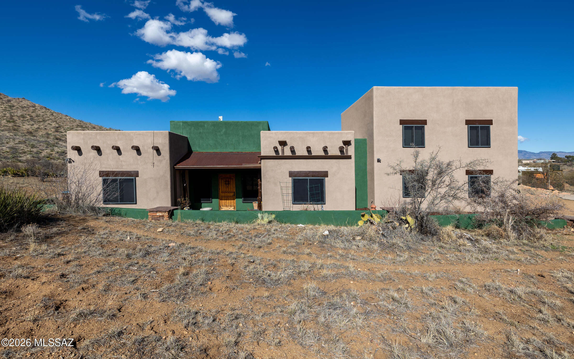 Discover your dream retreat living on 4.82 acres with captivating views of the Santa Rita Foothills and the open desert. This 5 bed/3 bath custom built home offers spacious elegance, with 3 downstairs  bedrooms, including the owner's suite, and two upstairs with a full bathroom. Gourmet kitchen features alder wood cabinets, granite countertops, and double ovens. Owner's suite indulges with a jacuzzi tub, walk-in steam shower and double vanity and walk-in closet. The full length patio with TG ceiling, is a great place for gathering and enjoying the exterior paint! Your oasis awaits!