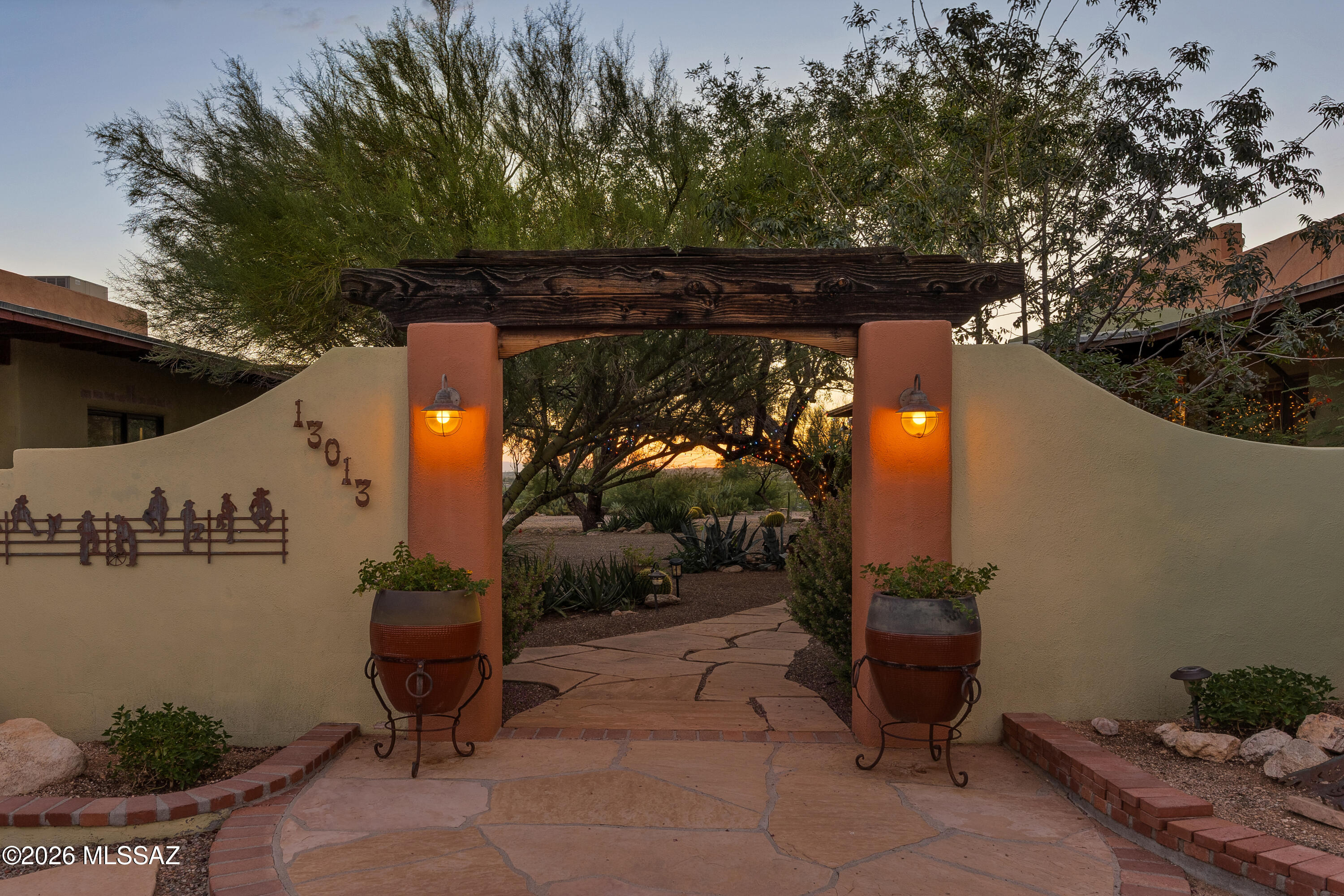 Located on Deep Well Ranch, this property is a desert sanctuary steeped in Tucson history. The 1935 residence occupies 3.3 privately owned acres surrounded by approximately 445 acres of conservation land. The protected virgin land provides a remarkable sense of scale, privacy, and uninterrupted desert, allowing the setting to feel far more expansive than its surveyed boundaries suggest. Designed in 1935 by pioneering architect Annie Graham Rockfellow, Arizona's first registered female architect. Robert Bass (New Hampshire Governor 1911-1913) commissioned the residence when the family relocated to Tucson. Historical accounts indicate that this home, which was the original guest house, served as a separate residence for the couple's children and their nanny. Continued... Rockfellow's regional Southwestern design responds naturally to the climate and landscape through burnt-adobe construction, the U-shaped design, and many indoor/outdoor access points.
A gated entrance opens to a walled courtyard with flagstone paving, an outdoor fireplace, and organic planting beds. Inside, original scored-concrete and brick floors preserve the home's historic character. The living room with a fireplace sets the stage for the character and charm found in each room of the house and leads to a screened-in porch area. The three updated bathrooms incorporate period-sensitive custom-cabinetry and Carrara marble countertops. The third bedroom, originally the nanny's quarters, offers a private entrance and its own fireplace. The kitchen and adjacent pantry open to the dining room for ease of entertaining. The bonus room can serve as an art studio, office, craft room, or an additional bedroom.  Just off the primary suite, a screened porch overlooks the unfenced natural desert and a small pond that attracts local wildlife. Steps lead up to the roof, from which you can enjoy panoramic mountain, desert and sunset views. A private trail leads to a hillside promontory overlooking Alhambra Wash and the protected landscape beyond- an ideal vantage point for Tucson's iconic sunsets. The surrounding conservation land encompasses a rich Sonoran desert landscape with native mesquites, sweet acacia and palo verde trees along the lowland wash and saguaros, ocotillo, agave and barrel cacti across the upland desert. The masonry-stucco 772 sq. ft. guesthouse features extensive custom
woodwork, built-in cabinetry, a kitchenette, a large bedroom area, and an ensuite bathroom with a shower and a tub.
The attached garage offers additional storage and a room for a workshop. A plant-propagation room was added south of the garage, ideal for nurturing plants to enhance the landscape. The residence is set within the lush Tanque Verde Valley, often described as the green jewel of the desert, where the foothills of the Catalina and Rincon mountains frame a landscape traversed by two seasonal creeks. Located minutes from the historic Tanque Verde Guest Ranch and the ranch long associated with Paul and Linda McCartney, the sparsely developed area is known for its extensive trails, star-filled skies, vivid sunrises and sunsets, mesquite bosques, and abundant desert wildlife.
The 952 sq. ft. storage shed is an added bonus, providing plenty of room for tools, bikes, seasonal items, landscaping equipment, and more. Just steps from the guest house/garage, making it convenient for daily use. 
Enjoy the best of the Arizona lifestyle with two nearby golf courses, Mt. Lemmon, Saguaro National Park East, and a multitude of hiking and biking trails from your doorstep. Shopping and restaurants are less than 10 minutes away. The University of Arizona/downtown Tucson is approximately 30 minutes away. Modern improvements include mini-split heating and cooling systems, thoughtfully integrated without diminishing the home's historic character. Horses are permitted. Trails extend throughout the surrounding area, and a shared well serves four residences. Together, the architecture, conservation setting, and enduring connection to the Sonoran Desert create a property whose experience extends well beyond its 3.3 privately owned acres.
