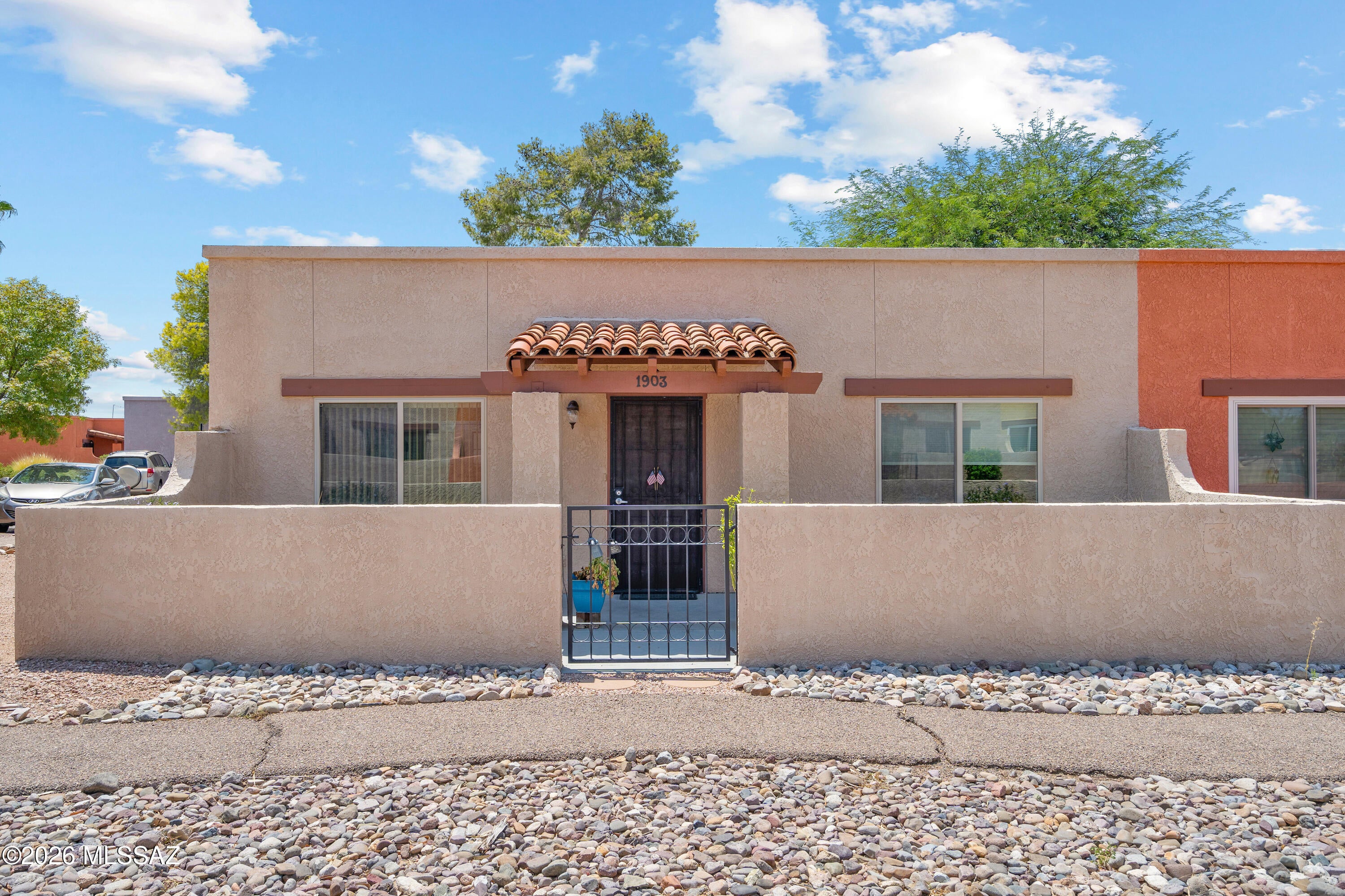 Charming 2-bedroom, 1-bath end unit in desirable Spanish Meadows! Enjoy a welcoming front courtyard with views of the common area & mountains, nearby visitor parking, and access to the community's heated pool. The home features porcelain wood-plank-look flooring in the bedrooms, decorator colors, and an updated bath with tile shower surround and executive-height vanity. The kitchen offers painted cabinetry with updated hardware, a pantry, and French doors leading to a beautifully landscaped rear yard--perfect for relaxing or entertaining. Attached carport includes convenient storage and a private laundry room. Newer roof & water heater (5 years old),  Assumable VA loan. Call LA for loan terms and balance. W & D, freezer & patio furniture available under separate bill of sale