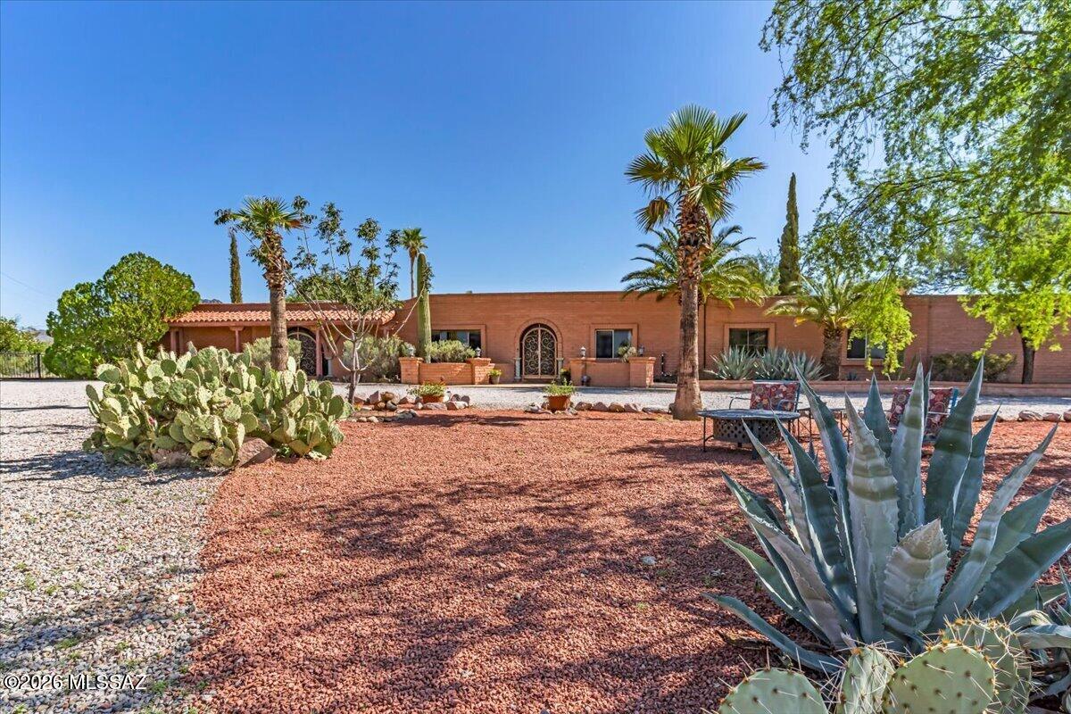 Discover this inviting Territorial ranch-style home offering exceptional character, versatility, and room to grow. This single-family residence has no HOA, offering added  freedom for its next owner. Currently operating as a successful bed and breakfast, this expansive property features 10 bedrooms and 7 bathrooms, including an attached guest suite with a separate entrance and a detached casita. The flexible layout offers exciting possibilities for a private residence, hospitality venture, retreat, or multi-generational living. More than $50,000 in renovations, repairs, and upgrades have been completed, including improvements to the electrical system, heating and cooling systems, roof, kitchen, bathrooms, and guest accommodations. Multiple guest rooms feature mini-split systems, three have private patios, and the attached guest suite includes double-pane windows, an upgraded bathroom, refreshed kitchen cabinetry, and ceiling fans.
Inside, architectural details create warmth and character, such as wood-beamed ceilings, French doors, Saltillo flooring, arched doorways, and two charming beehive fireplaces.
Set amid mature trees and lush landscaping, the grounds offer a peaceful desert setting with mountain views. A welcoming front seating area surrounded by shade trees, cacti, and palms provides a beautiful place to enjoy spectacular sunsets. Zoned for horses and located just minutes from Saguaro National Park West, the home offers convenient access to the beauty and recreation of the Sonoran Desert.
Outdoor amenities include an extra-large swimming pool, spa, fountain, remodeled cantina/barbecue area, and inviting patio spaces for relaxing and entertaining. Two rainwater harvesting tanks, a spacious two-car garage with built-in storage, and a workshop with additional storage behind the detached casita add practical value. A large concrete slab, formerly used as a basketball court, offers possibilities for a pickleball court or other recreational uses.
With its architectural charm, multiple living spaces, and beautiful desert surroundings, this unique property offers a rare opportunity to create something truly special. Come explore the possibilities.