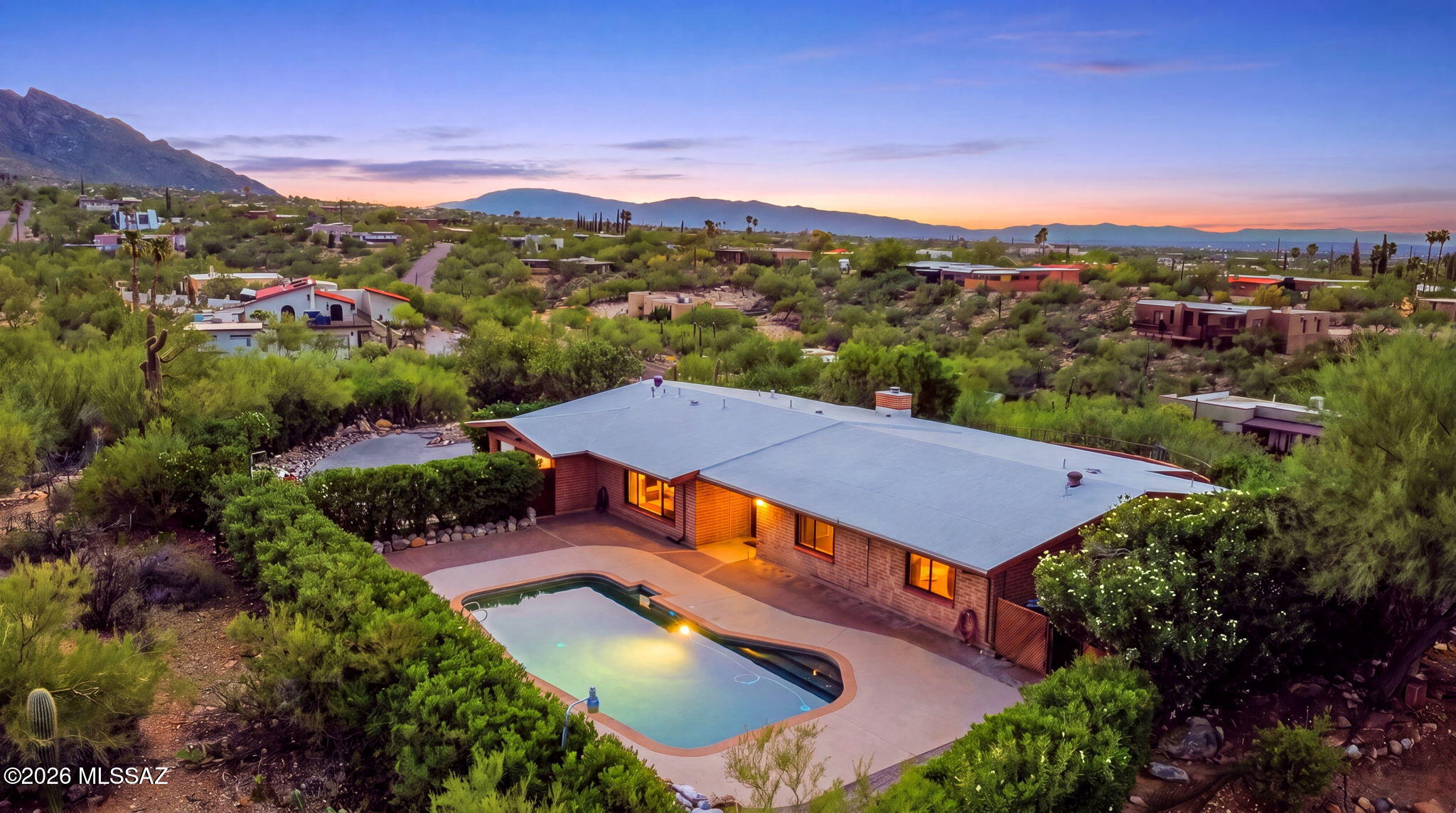 Perched on just over an acre with incredible city lights and sweeping mountain views, Moonridge offers space, privacy, and quintessential Arizona living. This 4 bedroom, 3 bath home features a desirable split floorplan with multiple living spaces, including a formal living room, formal dining room, spacious great room with fireplace, and a gorgeous library that brings warmth and character to the home. The well-designed layout offers flexibility for entertaining, working from home, or simply enjoying room to spread out.
Step outside to your own desert retreat, where a sparkling pool and expansive property create the perfect setting for enjoying Tucson's beautiful weather, breathtaking sunsets, and twinkling city lights. A paved driveway provides plenty of additional parking, while a large exterior storage shed and abundant interior storage make organization easy. The oversized laundry room adds even more functionality with extensive cabinetry and a utility sink.

With over an acre, exceptional views, a private pool, generous living spaces, and a floorplan designed for both everyday comfort and entertaining, this is a special opportunity to enjoy space, scenery, and the Southern Arizona lifestyle.

Let's not forget the prime location! Shopping, dining, outdoor activities, you have it all!