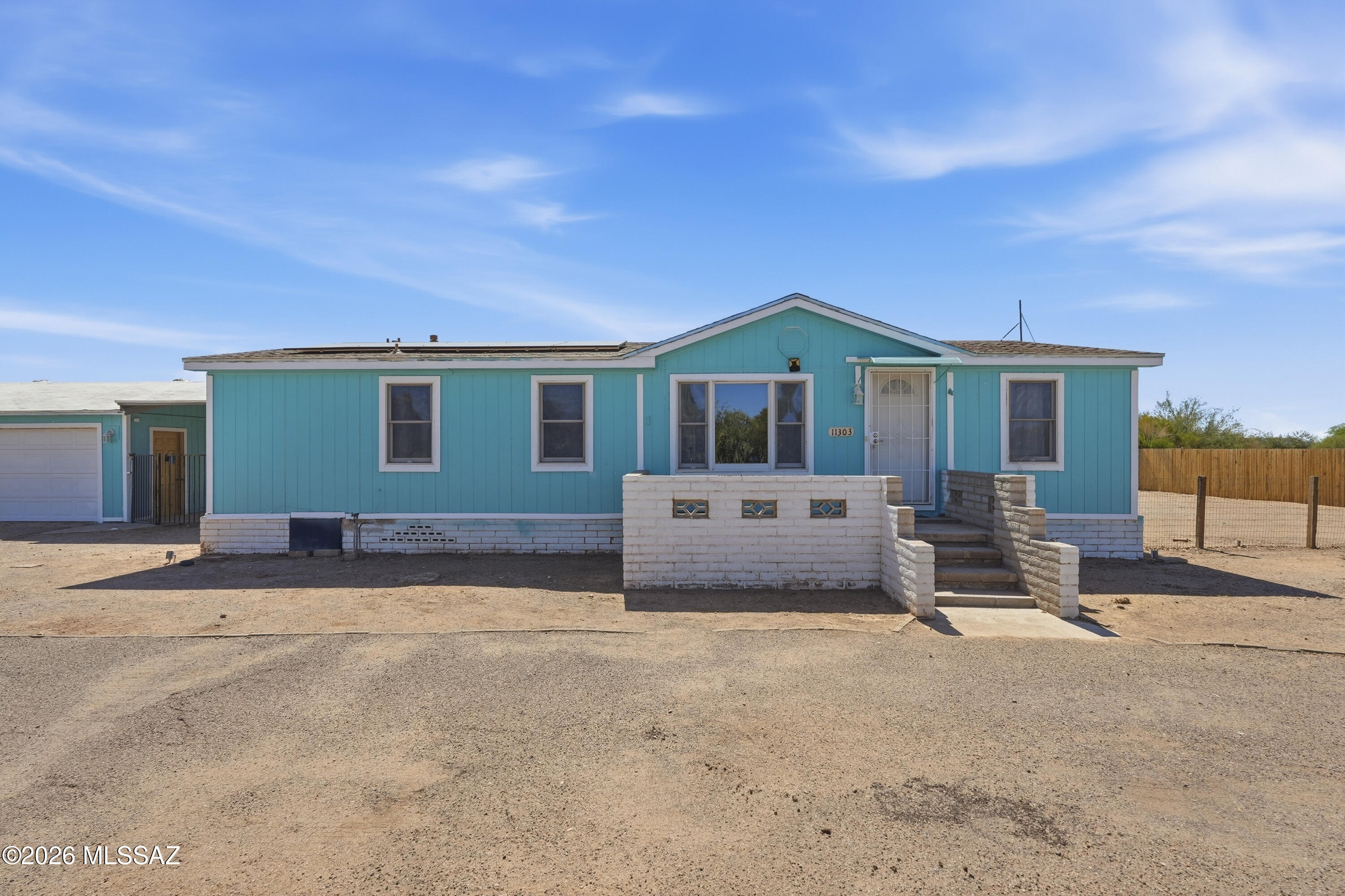 Enjoy peaceful country living with stunning mountain views, breathtaking sunrises, and spectacular Arizona sunsets from this well-maintained 3-bedroom, 2-bath manufactured home situated on a full acre. The property features a detached 2-car garage with workshop, plus an impressive 24' x 36' x 18' RV garage offering ample space for RVs, boats, toys, or additional storage. Relax on the large covered back porch overlooking the fully fenced backyard, perfect for pets, entertaining, or enjoying the outdoors. With room to spread out, this property offers the ideal blend of comfort, functionality, and wide-open space. Bring your horses and toys! A 1-year home warranty will be provided for peace of mind.