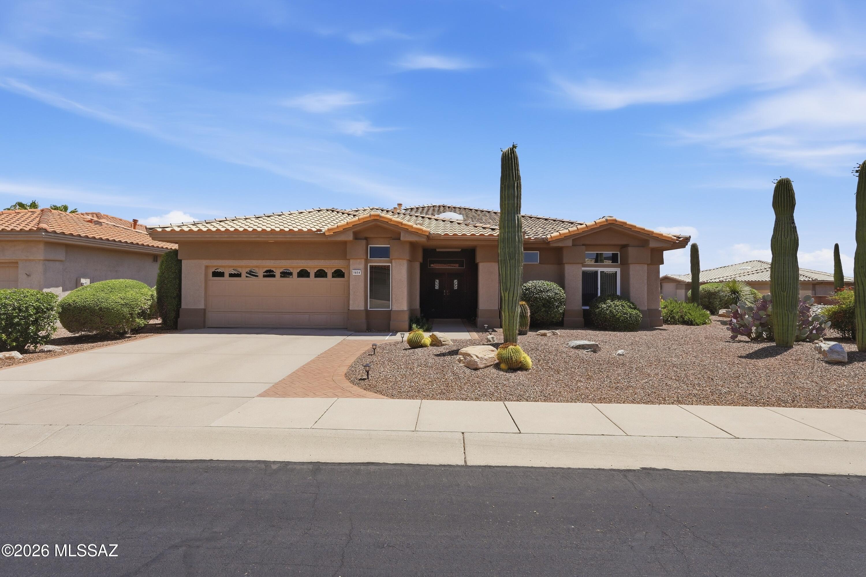 Discover the ideal blend of gorgeous mountain views and resort-style living nestled in the active adult community of Sun City Oro Valley. This 3BD/2BA+Office/Hobby Room (2,237sqft) beautifully designed expanded Sunrise Model masterfully maximizes single-level living with an abundance of natural light and zero interior steps. The home features an exceptionally fluid open-concept layout that seamlessly connects the main living spaces. At the heart of the daily routine is a welcoming living room off the kitchen, complete with a cozy gas fireplace that creates the perfect focal point for cool desert evenings. For hosting more formal gatherings, the layout boasts a combined formal living and dining area. This home uniquely prioritizes modern work-from-home or hobby needs by featuring three spacious bedrooms plus a dedicated separate office space. The private primary suite serves as an ideal retreat, showcasing an expansive layout, a large walk-in closet, a master bath complete with a deep garden tub, and a separate walk-in shower with bench seating. Step outside to experience a serene and manageable outdoor haven situated on a desirable, elevated, corner lot. The rear yard is fully wrapped in secure slump block view wall, keeping the space private while allowing the beautiful desert breezes to flow through. Relax on the covered back patio or dine alfresco on the extended paver patio area, all framed by low-care desert plantings. Living on Crown Ridge Way awards you front-row access to beautiful mountain views, and a rich community lifestyle. You are less than a mile from premium neighborhood features, including the recreational walking trails at Honey Bee Park. With comprehensive access to tennis courts, swimming pools, pickleball, and athletic centers, this residence delivers the ultimate active-adult lifestyle. Views!
