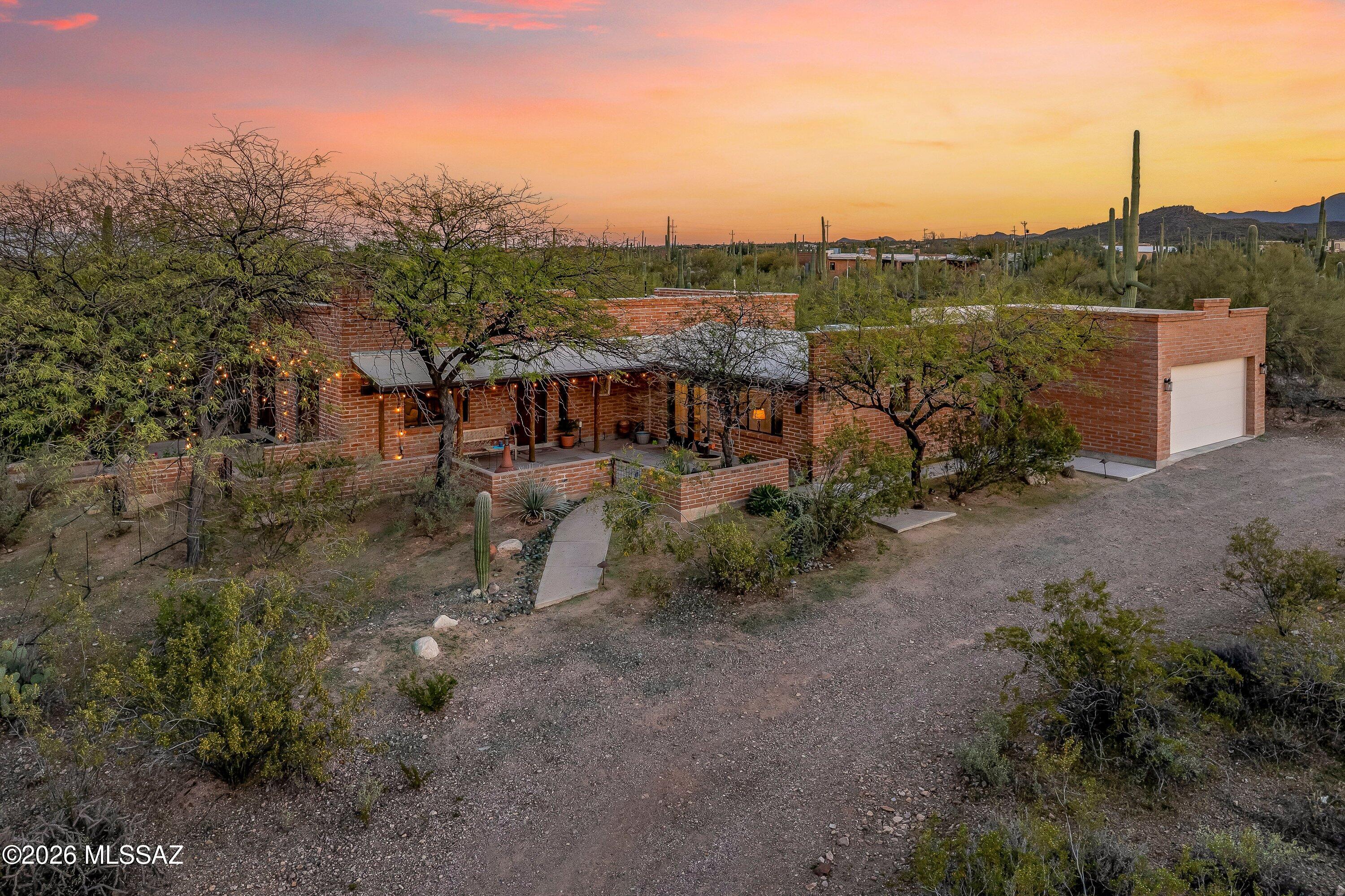 RARE FIND! 3.31-ACRE private oasis in the desirable Tucson Mountains! The main house is 2BR/2BA, PLUS an attached 1BR/1BA guest suite w/ private entrance. Perfect for multi-generational living, home office, gym or short/long term rental. The backyard is a birdwatcher's paradise with mature desert landscaping, towering saguaros and panoramic views of multiple mountain ranges. This inviting home showcases  exposed brick interior walls that add rich texture, timeless appeal, and a cozy traditional Kiva fireplace anchors the living room  adding authentic Southwestern character.  Natural light pours in, highlighting the earthy tones and creating a warm, welcoming atmosphere throughout.  Opportunities like this in the Tucson Mountains are rare. Enjoy privacy and acreage while being minutes from hiking and biking trails, restaurants, shopping, schools, and convenient I-10 access. Secure the space, views, and lifestyle you've been waiting for before it's gone.