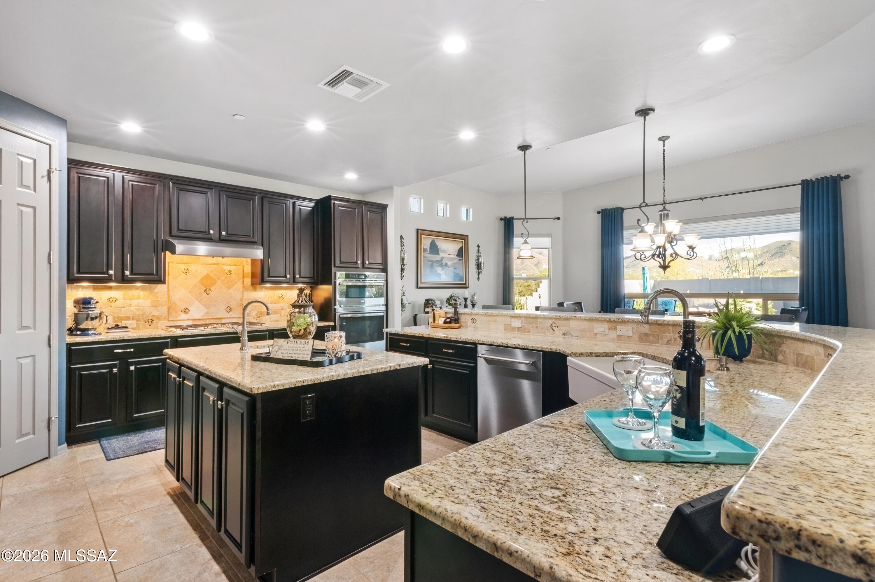 Spectacular Mountain Views & Resort-Style Living in the Gated Estates at Sycamore Canyon. Perched on a private .81-acre cul-de-sac lot, this stunning Sonoran retreat offers breathtaking panoramic views of all four Tucson mountain ranges. Built by Sombra Homes and beautifully refreshed with new exterior and interior paint, the home blends timeless Southwest architecture with refined comfort. Come inside to soaring ceilings, picture windows, and a dramatic floor-to-ceiling gas beehive fireplace anchoring the Great Room. French doors open to an extraordinary backyard designed for both relaxation and entertaining. The chef's kitchen is the heart of the home, featuring granite countertops, a 5-burner gas cooktop, farmhouse sink, large island with prep sink, and abundant workspace-- perfect for gathering with family and guests. A thoughtful split floor plan offers 3 spacious bedrooms, 3 baths, and a private office/den, along with a 3-car garage. Outside, the backyard feels like a private resort. Enjoy a sparkling pool with waterfall, separate heated spa, fire-pit lounge, and a ramada with built-in BBQ and bar seating--all set against sweeping desert and mountain vistas. Additional highlights include stone-look tile flooring inside and out, No Carpet, custom doors, 9' ceilings, lush landscaping, and a peaceful end-of-cul-de-sac setting. Located within the highly regarded Vail School District, this exceptional property offers the perfect blend of privacy, luxury, and unforgettable desert views. Simply arrive, unpack, and enjoy the lifestyle.