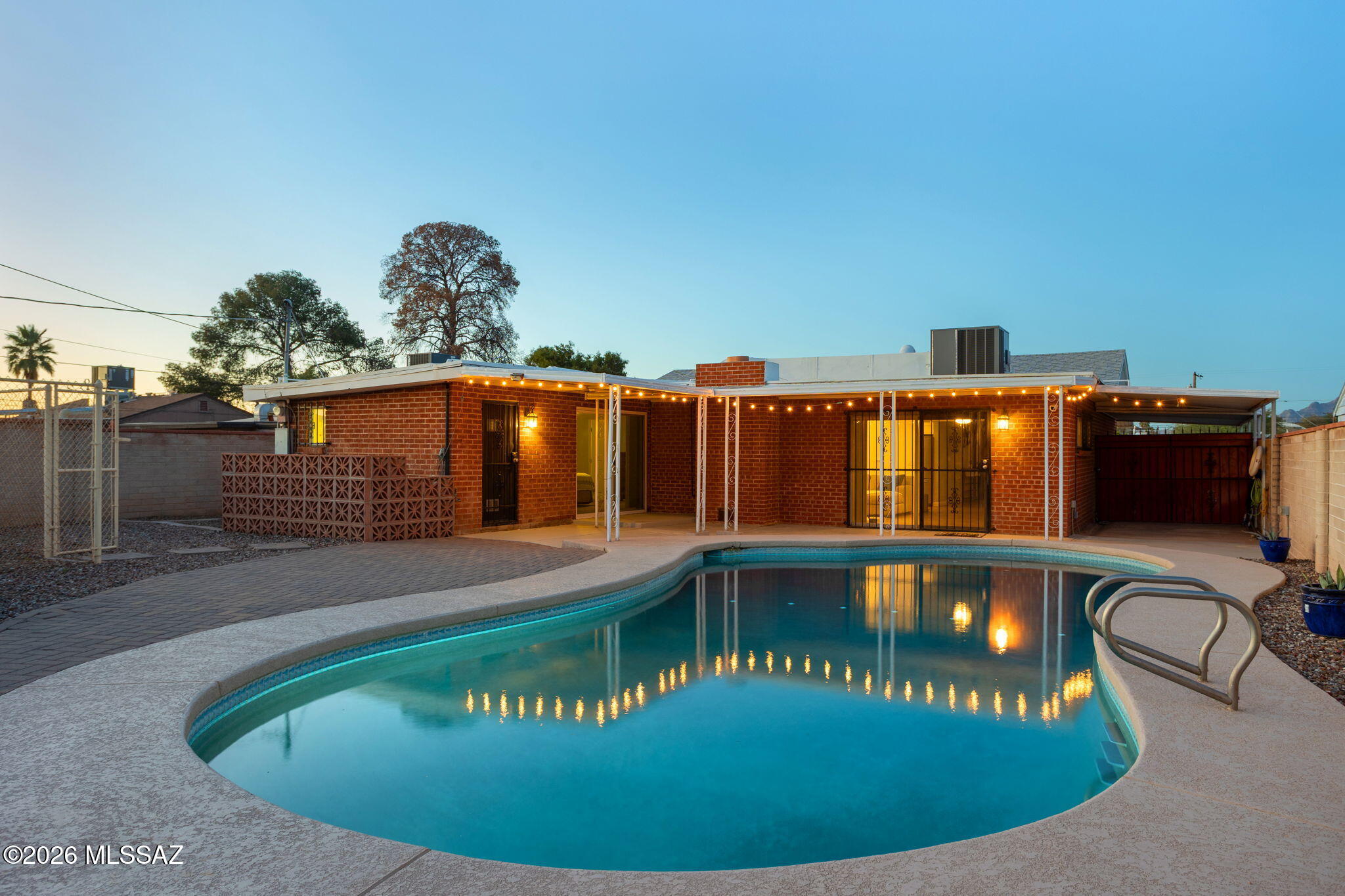 Home with pool just one mile away from the University of Arizona campus and close proximity to Downtown! Updated home features wood plank tile throughout, with upgraded carpet in the bedrooms. The kitchen has upgraded cabinets, granite countertops, and a decorative backsplash. The spacious floor plan includes split bedroom, a family room with a brick fireplace, and a front living room. Additionally, both bathrooms feature tile surrounds for the shower and tub, and the home has upgraded dual pane windows. Outside offers a large backyard with a pool surrounded by cool decking and an extended paver patio. There is a side yard with two wood storage sheds, and the front yard features mature fruit trees, a paver walkway, and an extended driveway.