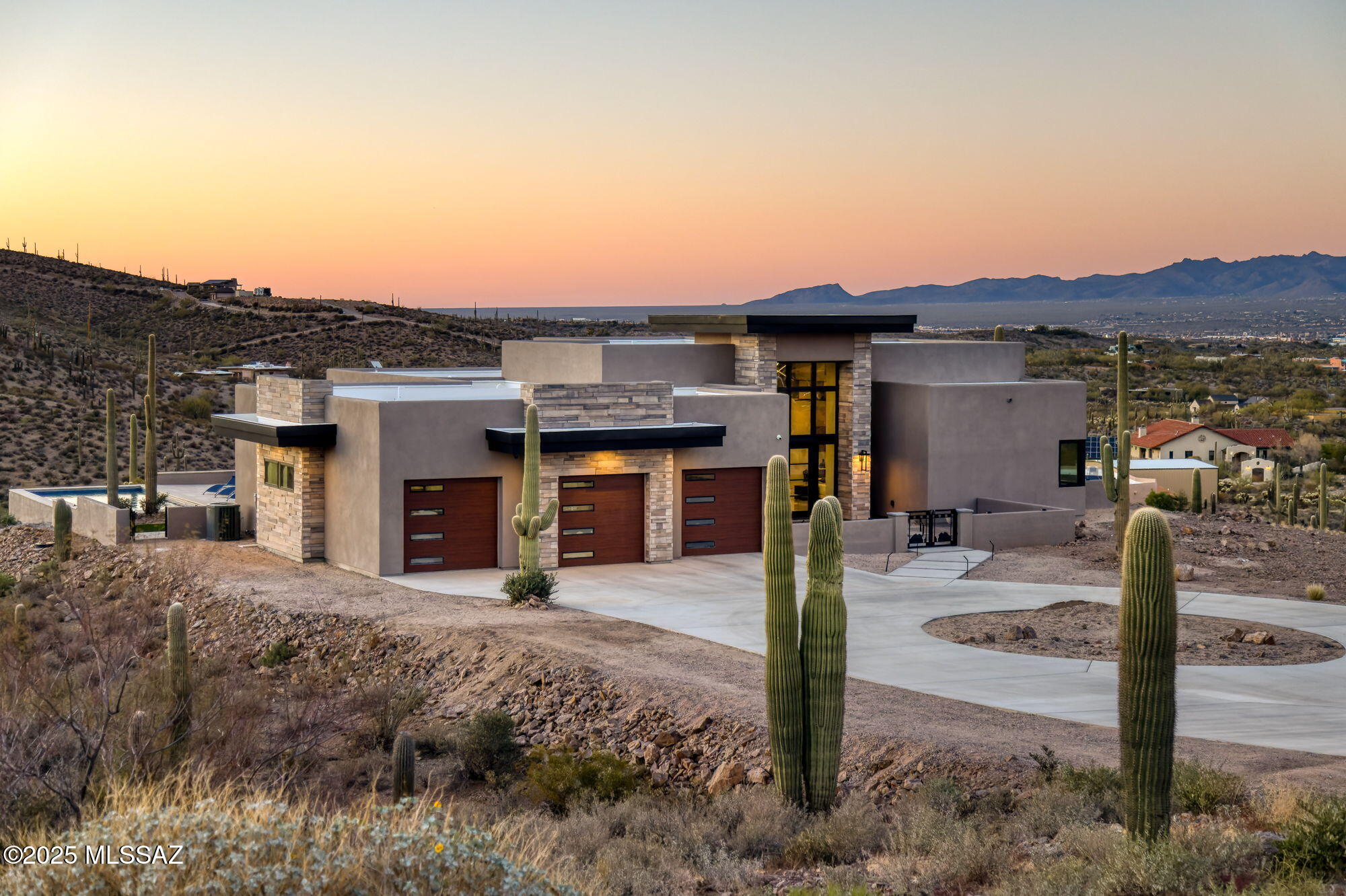 Seller is a Midwest Architect & Builder who specializes in designing and building high end homes. This property showcases his skills and workmanship. Perched in one of Tucson's most coveted gated communities, this stunning ultra-contemporary residence redefines year-round luxury living. A striking cantilevered porch entry and bold architectural lines introduce the home's meticulously curated design, setting the tone for the sweeping east-facing views of iconic mountain ranges and striking modern architecture that set this home apart. Set on a premium lot surrounded by towering saguaros, the home captures unending vistas—sunrises that awaken the mountains, city lights that twinkle at dusk, and sunsets that paint the sky with vibrant color. Thoughtfully designed, this custom home offers over 3,400 square feet of refined indoor living, featuring 4 bedrooms, polished marble flooring, and a show-stopping ceiling-to-floor stone fireplace with a modern linear gas fireplace. 
 
A gourmet kitchen and dining area provide the ideal space for unforgettable culinary experiences, inside, opulence meets functionality in the oversized commercial-grade equipped chef's kitchen adorned with top-of-the-line stainless steel appliances, a black leather island, a Sub-Zero refrigerator,  artisan tile, and lighting. 
 
The private primary suite is a retreat, complete with a modern linear gas fireplace, built in tv, freestanding soaking tub, black leather-accented double vanities, and cutting-edge glass and tile.  
 
The indoor-outdoor connection is unparalleled, with a 4 car garage, expansive deck, stone deck accented with steel featuring a built-in-BBQ, outdoor kitchen, spa, lap pool with a retractable pool cover, wood plank ceilings with fans, and modern tile work. and fire pit set up to create a true retreat for relaxing or entertaining.
 
This stunning custom residence embodies a statement of modern desert living, reimagined with style, vision, and timeless appeal.