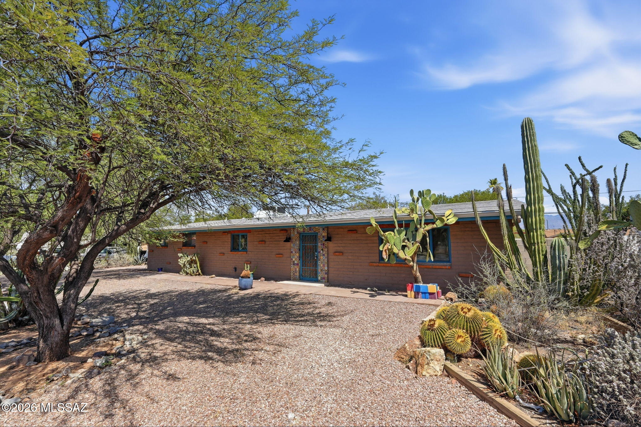 Historic charm meets modern comfort in this beautifully updated burnt adobe home. The remodeled kitchen features a gas range, quartz countertops, a farmhouse sink and stainless appliances. Beamed and vaulted ceilings, skylights, and freshly refinished Saltillo tile add character and style. Updated baths and newer window coverings offer modern convenience. Spacious secondary bedrooms provide plenty of room for guests. The oversized lot offers room to add a garage or ADU. Also a separate workshop that could be converted to a studio. Ample parking with semicircle and standard driveways. Fully enclosed backyard with multiple patios, fire pit and rainwater harvesting tanks.  This unique property offers character, versatility, and an unbeatable location close to Reid Park and downtown amenities.