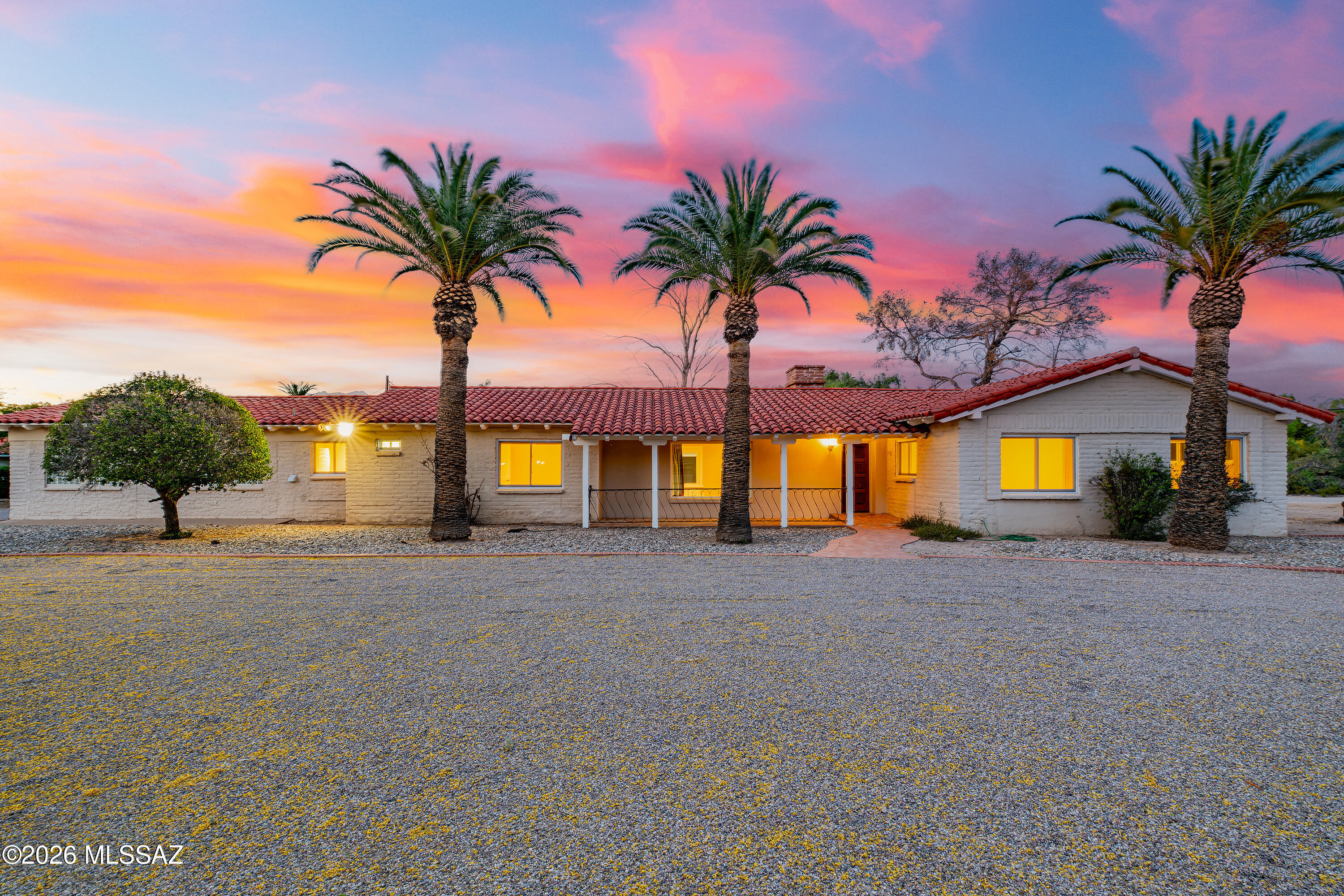 Classic Burnt Adobe Spanish Mission Style home with tile roof. The home sits on a large .86 acre lot. Step into the updated interior with updated kitchen and bathrooms. Large Great room with wood burning fireplace that opens onto the updated kitchen with newer cabinets and granite counter tops. Plus an Arizona Screened in porch, that opens out to the sparkling below ground pool that have views of the Catalina Mountains! This 3 bedroom/plus den has a great floor plan with a separate bedroom and bath on the west end of the home. This large lot abounds with possibilities.