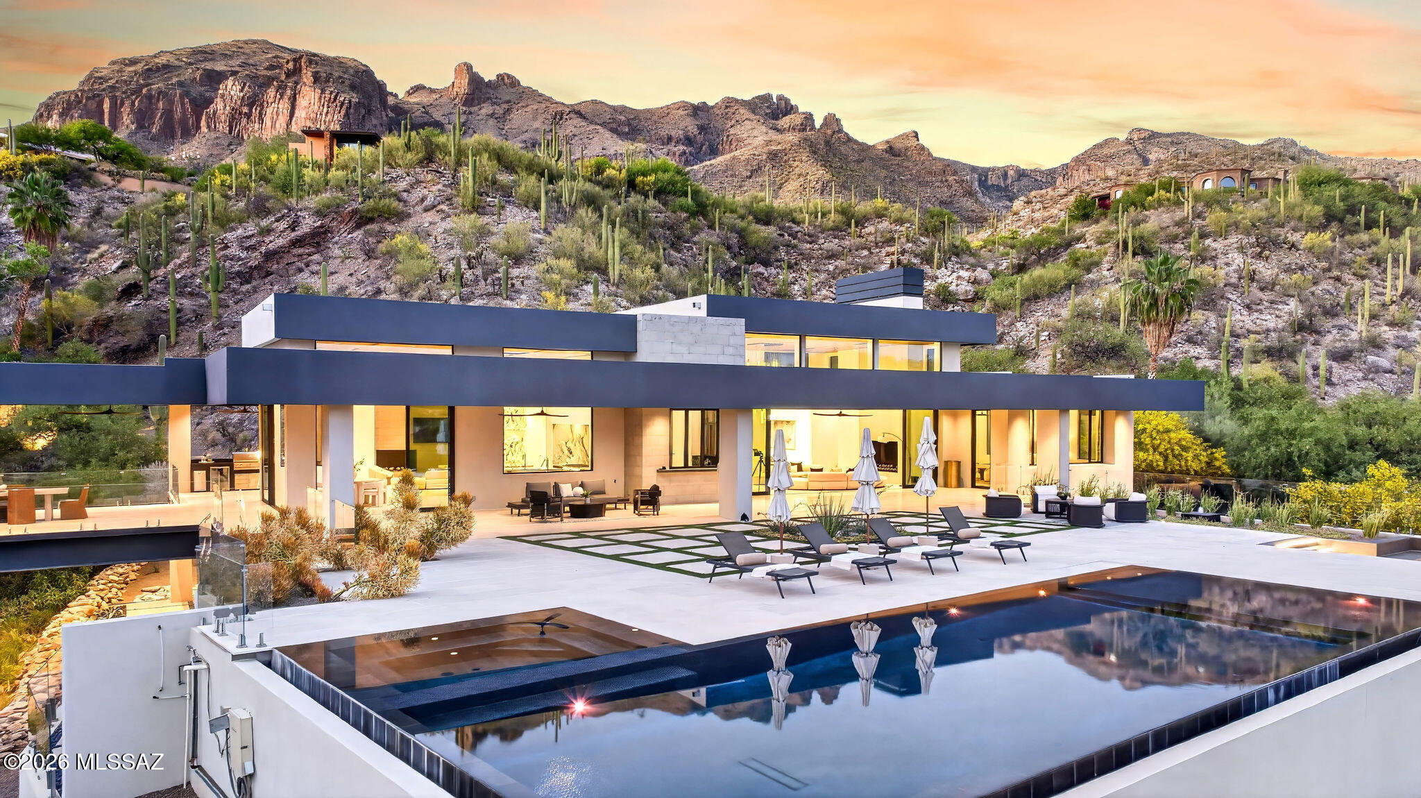 Set behind the gates of The Canyons, Tucson's most exclusive Foothills enclave, this newly constructed architectural masterpiece redefines desert luxury! Privately sited on 5 pristine acres, the estate captures breathtaking views while delivering a rare sense of seclusion just minutes from Tucson's finest amenities. Designed with obsessive attention to detail, walls of glass and soaring 18-foot ceilings blur the line between indoors and out. From dual onyx islands and bespoke finishes to a resort style pool and sky bridge, every element has been curated for those who demand extraordinary design, ultimate privacy, and world-class entertaining! 

Welcome to one of the most compelling luxury offerings ever presented in the Catalina Foothills, (continued) an architecturally significant estate in the prestigious guard-gated community of The Canyons! Widely regarded as the crown jewel of Tucson living, this enclave is synonymous with prestige, privacy, and estate-caliber residences. Yet even among such distinction, this newly completed home stands alone!

Privately positioned on five acres, the property delivers an experience rarely found: complete serenity, unobstructed desert beauty, and a feeling of being worlds away while remaining just five minutes from Tucson's finest dining, shopping, and lifestyle destinations!

From the moment of arrival, the home reveals its intention. Clean architectural lines meet warm, natural materials--limestone, onyx, granite, and custom wood detailing--creating a balance of modern sophistication and organic desert elegance. Inside, soaring 18-foot ceilings and expansive walls of glass invite the Sonoran landscape inward, flooding the home with natural light and framing panoramic mountain and city views.

Designed for both grand-scale entertaining and intimate living, the residence flows effortlessly through retractable glass walls that dissolve boundaries between interior and exterior spaces. Every room is purposeful. Every finish, intentional.

At the heart of the home, the kitchen is nothing short of a showpiece crafted for culinary excellence and social connection! Dual book matched onyx islands anchor the space, complemented by a suite of Miele and Thermador appliances, a fully equipped butler's pantry, and a dedicated bar service area. Whether hosting lavish gatherings or quiet evenings, the space performs flawlessly!

The primary suite is a private retreat of extraordinary scale and detail. Rich wood inlays, dramatic tray ceiling accents, and a statement fireplace create warmth and sophistication. The spa-inspired bath features a sculptural soaking tub, expansive walk-in shower, and luxurious finishes throughout. A dedicated "ready room" and a celebrity-caliber closet elevate daily living into a curated experience of style and ease.

Each guest suite is thoughtfully designed as a private haven, complete with ensuite baths and bespoke material selections that echo the home's refined aesthetic.

Beyond the living quarters, the estate offers a collection of amenities rarely found in a single residence. A climate-controlled wine room and cellar, private home theater, fully equipped fitness studio, and walk-in safe speak to both lifestyle and security. A 16-car garage provides space for the most discerning automotive collections.

One of the home's most unforgettable features is the "gold cave"--a striking nod to the area's rich mining history--delivering a one-of-a-kind conversation piece and experiential element that sets this property apart on a global scale. The sky bridge further enhances the architectural intrigue, connecting spaces in a way that is both functional and visually captivating.

Outdoors, the estate transforms into a private resort. A negative-edge pool and spa appear to spill into the desert horizon, surrounded by multiple lounge and entertaining areas designed for both day and evening enjoyment. Fire features, an outdoor kitchen, and expansive patios create an atmosphere that is at once vibrant and serene.

Above all, the privacy is extraordinary. The scale of the land, the positioning of the home, and the natural desert surroundings create a level of seclusion that is nearly impossible to replicate, especially this close to the city's best amenities.

This is more than a home. It is a statement. A sanctuary. A rare convergence of architecture, craftsmanship, and location designed for a world-class buyer who expects nothing less than perfection!
