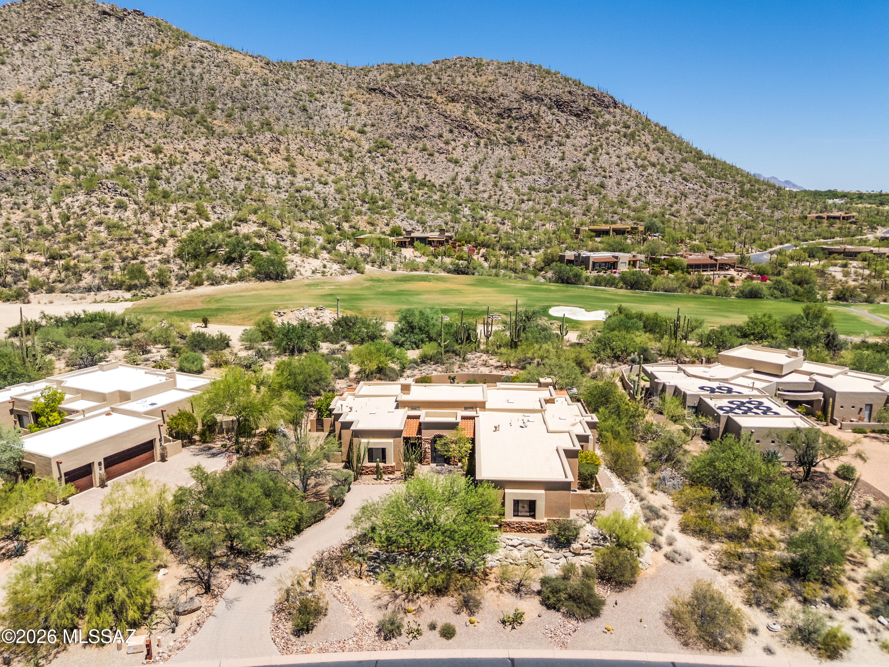 Indulge in a masterclass of elevated high-desert refinement with this exquisite custom-built single-story estate, beautifully positioned directly along the manicured 16th fairway of The Gallery North Course. Nestled inside the prestigious, gated Solana enclave of Dove Mountain, this 4BD/3BA/2Half BA (3,626sqft) sanctuary seamlessly pairs majestic mountain vistas with magnificent indoor-outdoor entertaining spaces. From the moment you step through the custom glass and wrought-iron entrance door, you are greeted by an atmosphere of unmistakable luxury. Soaring ceilings and rich knotty pine flooring stretch across the main living zones, creating an elegant backdrop for daily life. The home features two dramatic stacked-stone fireplaces thoughtfully designed with hidden wiring for flat-screen displays, perfectly complementing both the grand formal spaces and the relaxed casual gathering areas. At the heart of the residence is a chef-inspired gourmet kitchen. This culinary haven is anchored by rich Knotty Alder cabinetry, solid granite countertops, and premium integrated appliances, all looking out to the stunning scenery beyond. The expansive four-bedroom footprint is intelligently laid out to prioritize both individual privacy and comfortable shared living. The primary suite serves as a resort-style retreat, while a highly versatile floor plan accommodates guest suites and flexible space for a custom home office or media lounge. The indoor flow transitions seamlessly out into a truly elite backyard oasis. Relax or host on the massive, deep-set covered patio, which frames spectacular, unobstructed views of the Tortolita Mountains. The outdoor amenities rival those of a five-star resort, highlighted by a sparkling custom pool and spa with a convenient pool-accessible bath, a built in BBQ, and a cozy fire pit perfect for cool desert nights beneath the stars. Furthermore, you are located only minutes from fantastic hiking and biking trails, world-class amenities at The Gallery Golf & Sports Club, Golf Clubs Dove Mountain, and The Ritz-Carlton Resort and Spa.