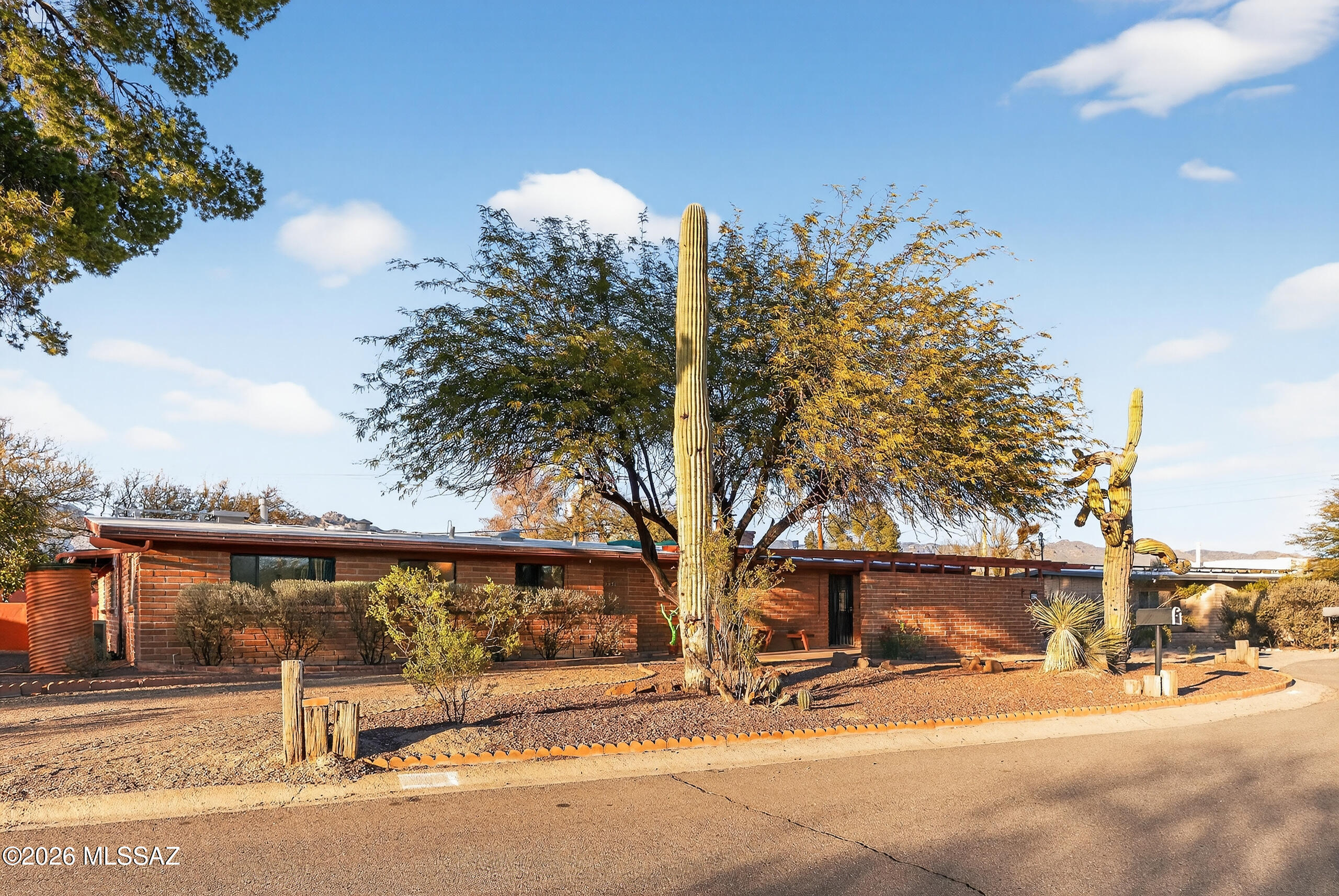 Motivated Seller Offering $10,000 credit toward closing costs or interest rate buydown. Welcome to the Historic Indian Ridge District, where the past and present blend effortlessly. Built in 1958, this meticulously maintained burnt adobe midcentury home offers 4 bedrooms, 2 baths, and 2,481 sq ft of authentic Tucson character. An expansive living room with fireplace, open wood beam ceilings, and abundant natural light showcases the warmth and craftsmanship of the era. Spanish tile floors and true burnt adobe construction create a welcoming, timeless feel. Enjoy a versatile Arizona room, large yard with native landscape, plus workshop and generous storage. Near the Foothills yet minutes to Midtown, Indian Ridge offers rich history and strong community Motivated Seller Offering $10,000 credit toward closing costs or interest rate buydown. 

Welcome to the Historic Indian Ridge District, where the past and present live beautifully side by side. Built in 1958, this meticulously maintained burnt adobe mid-century home offers 4 bedrooms, 2 bathrooms, and 2,481 sq ft of timeless character, highlighting the warmth and craftsmanship that only true mid-century design can offer. Inside the home features an expansive living room with a fireplace, open wood beam ceilings, and abundant natural light. Authentic burnt adobe construction and classic Spanish tile flooring reflect the architectural integrity of the era while creating a warm, inviting atmosphere throughout. The Arizona room provides flexible additional living space ideal for relaxation, hobbies and entertaining.
The generous lot offers a large yard with native vegetation, mature fruit trees, a dedicated garden area, and mountain views. Outdoor living is enhanced by a serene front patio with a water feature, while a workshop and two large storage areas add exceptional practicality. Ideally situated near the Catalina Foothills yet conveniently close to Midtown Tucson, this home offers both tranquility and accessibility. Indian Ridge is celebrated for its strong sense of community, rich mid-century history, and enduring neighborhood pride, making this a rare opportunity to own in one of Tucson's most cherished historic districts.  Indian Ridge is a National Register Historic District with strong community traditions, from swim club to the Fourth of July Parade, Luminaries on Christmas Eve, classic Trick or Treating and the beloved "Retro in the Ridge," community isn't just a concept here, it's a way of life. Indian Ridge is the kind of place where people still know each other's names, kids ride bikes through the streets, and traditions matter. From the neighborhood 
Perfectly located near the Catalina Foothills while just minutes from Midtown dining, shopping, and culture, this home offers balance, beauty, and belonging. If you're looking for character, connection, and a home that truly feels like Tucson, this is it.